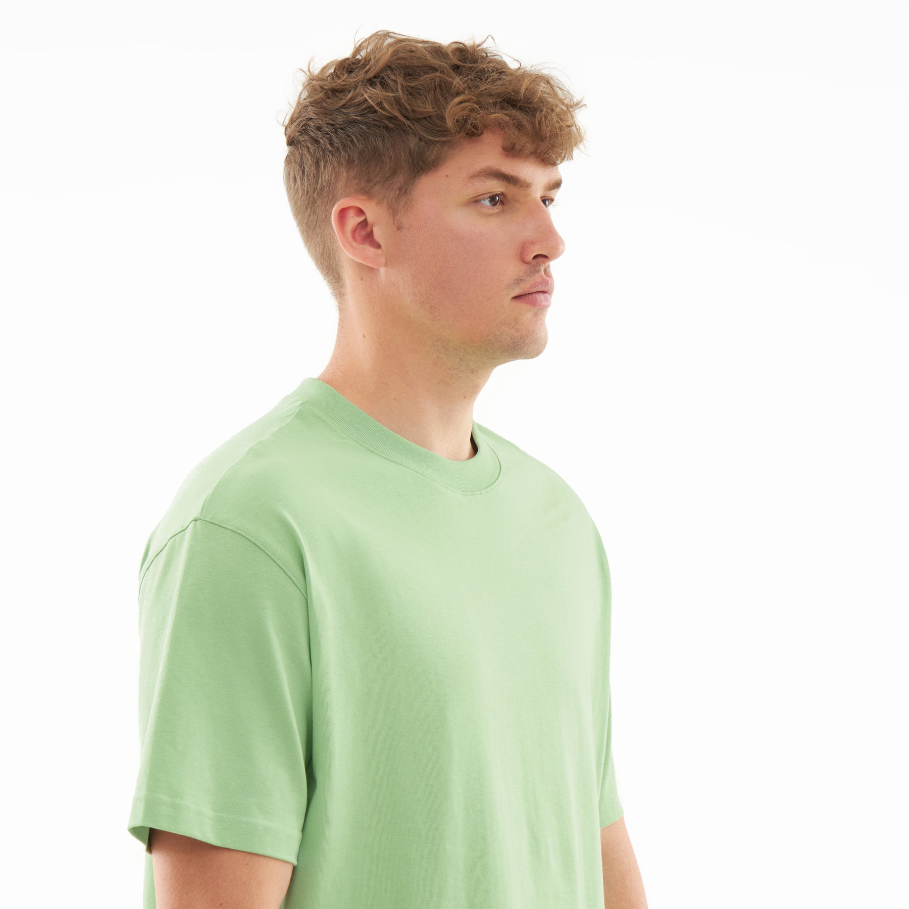 Mann im Profil trägt das sage-grüne T-Shirt 'Sammy'