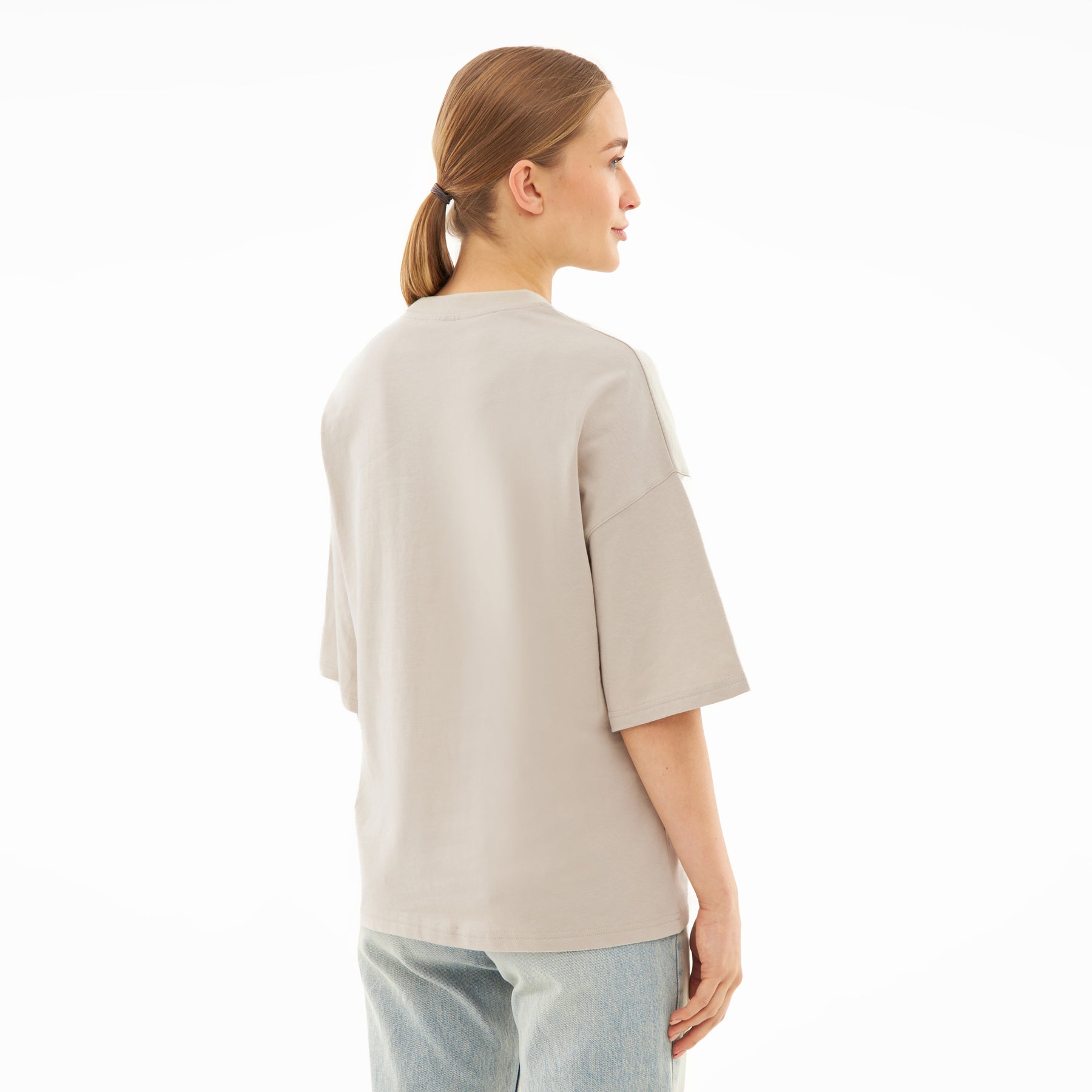 Damen trägt oversized T-Shirt 'Vic' in beige, Rückansicht, mit halblangen Ärmeln und lockerem Schnitt