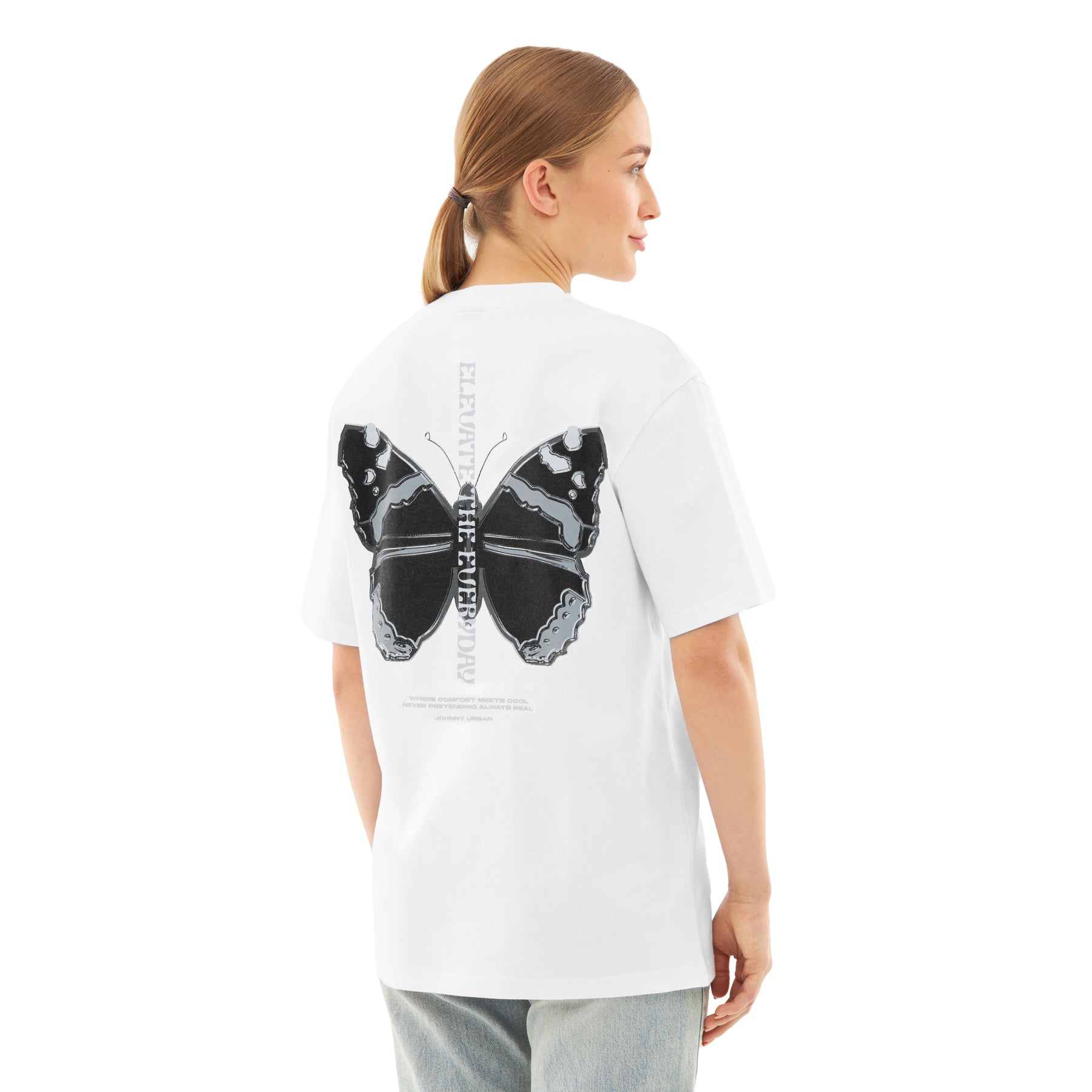 Frau mit Pferdeschwanz trägt weißes Oversize-T-Shirt 'Sammy Chrome Butterfly' mit großem schwarzem Schmetterlingsdruck auf dem Rücken