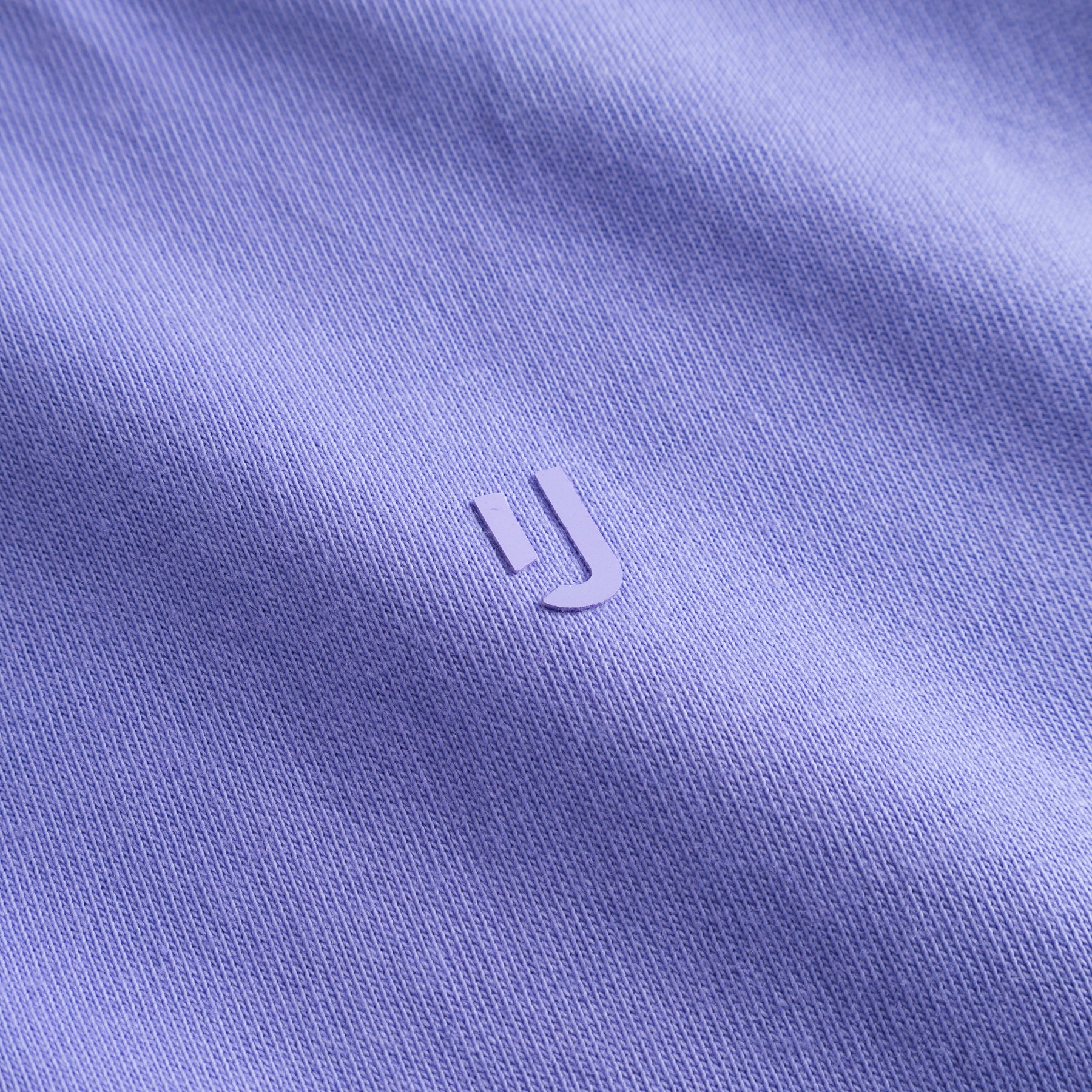 Nahaufnahme des violetten T-Shirts 'Sammy Chrome Butterfly' mit kleinem Johnny Urban Logo in der Mitte