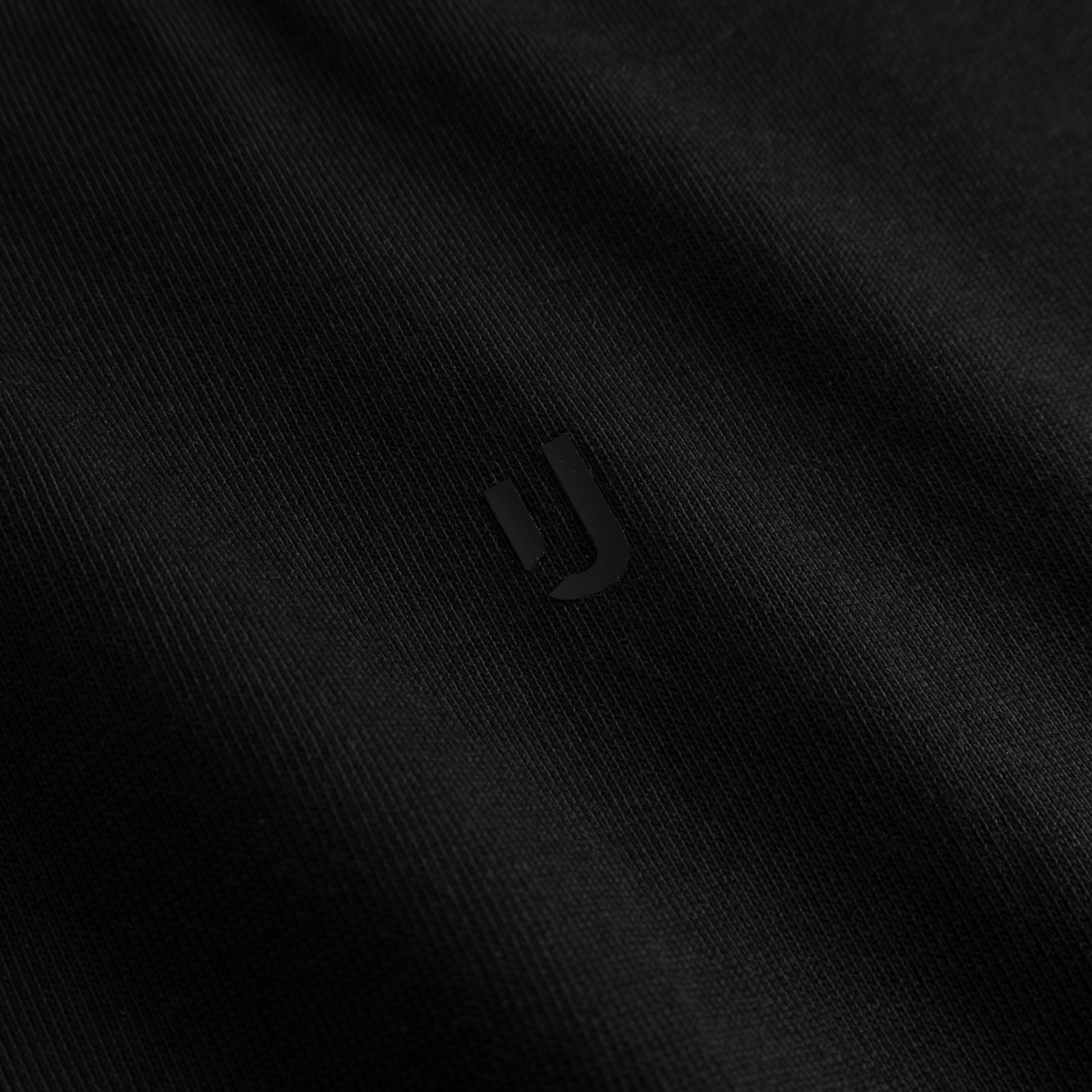 Schwarzer Stoff mit dezentem, glänzendem Johnny Urban Logo