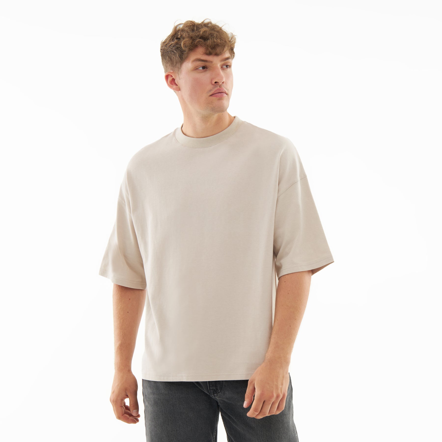 Mann trägt sandfarbenes T-Shirt 'Vic' mit lockerem Schnitt und kurzen Ärmeln