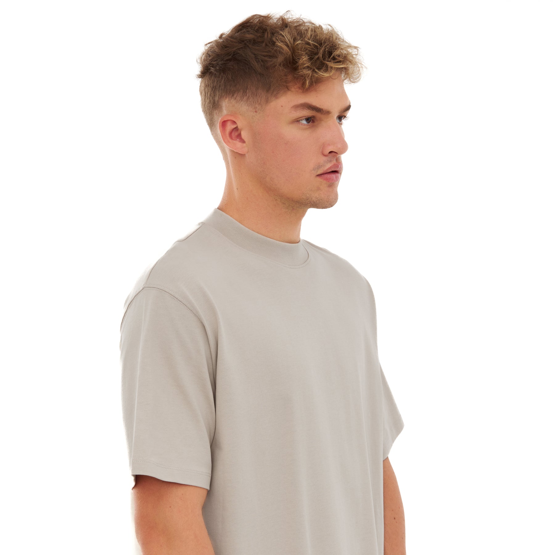 Mann mit kurzem lockigem Haar trägt beige T-Shirt 'Sammy' von Johnny Urban in moderner Passform