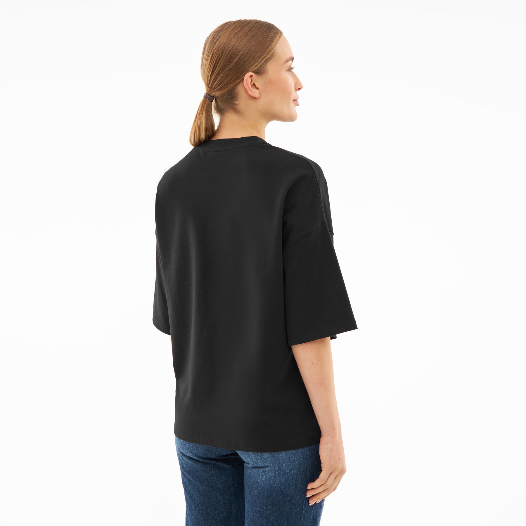 Frau trägt schwarzes T-Shirt 'Vic' mit lockerer Passform, Rückansicht
