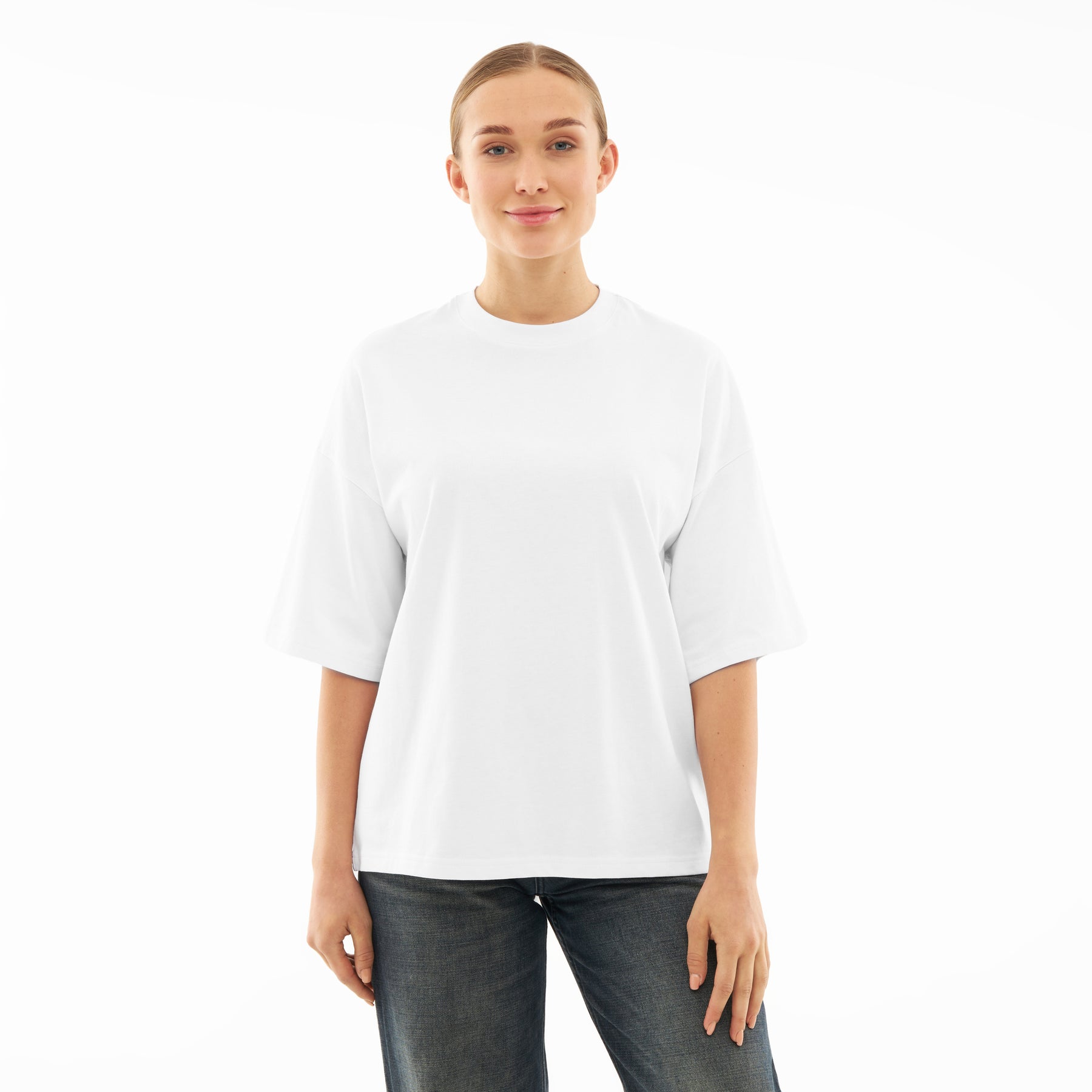 Frau trägt weißes T-Shirt 'Vic' mit halblangen Ärmeln und schwarze Jeans