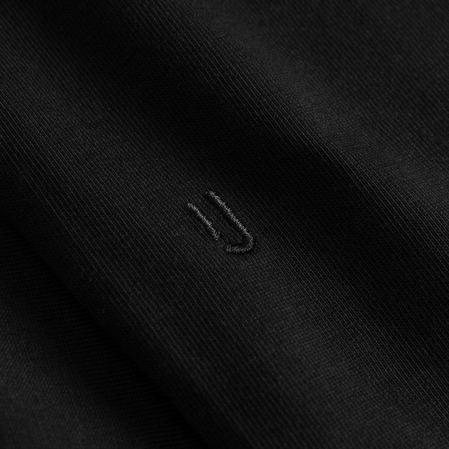 Schwarzer Oversize T-Shirt-Stoff mit dezentem, schwarzem Sticklogo