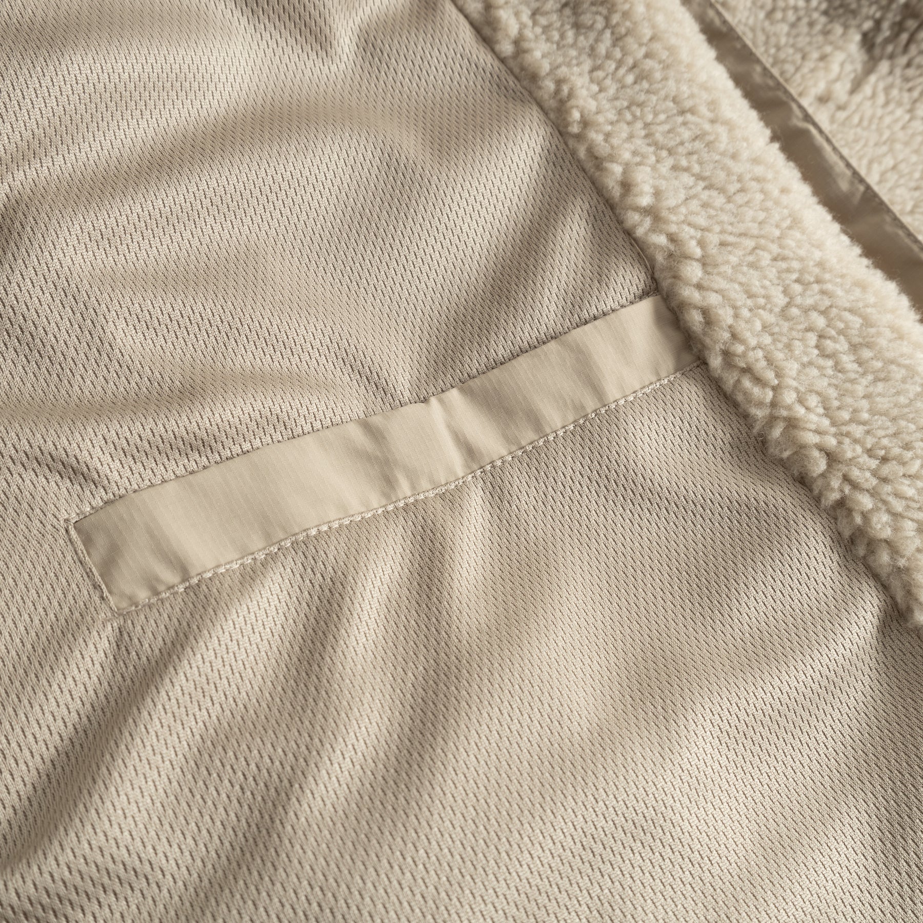 Innenansicht einer beigen Teddy Fleecejacke 'Carson' mit weichem Futter und Innentasche