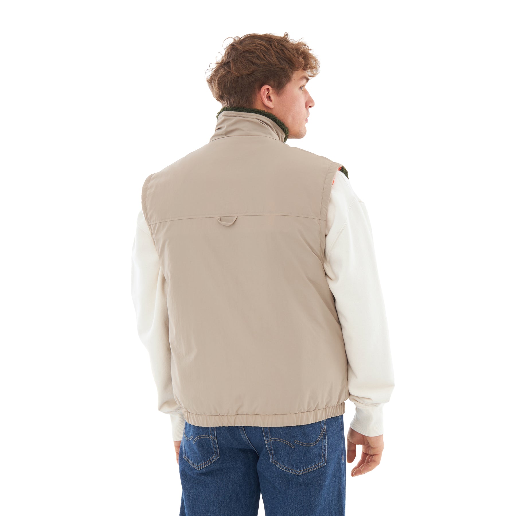 Rückansicht einer Person, die die sandfarbene, wendbare Teddy Fleeceweste 'Bryson' trägt, kombiniert mit weißem langärmligem Oberteil und blauen Jeans