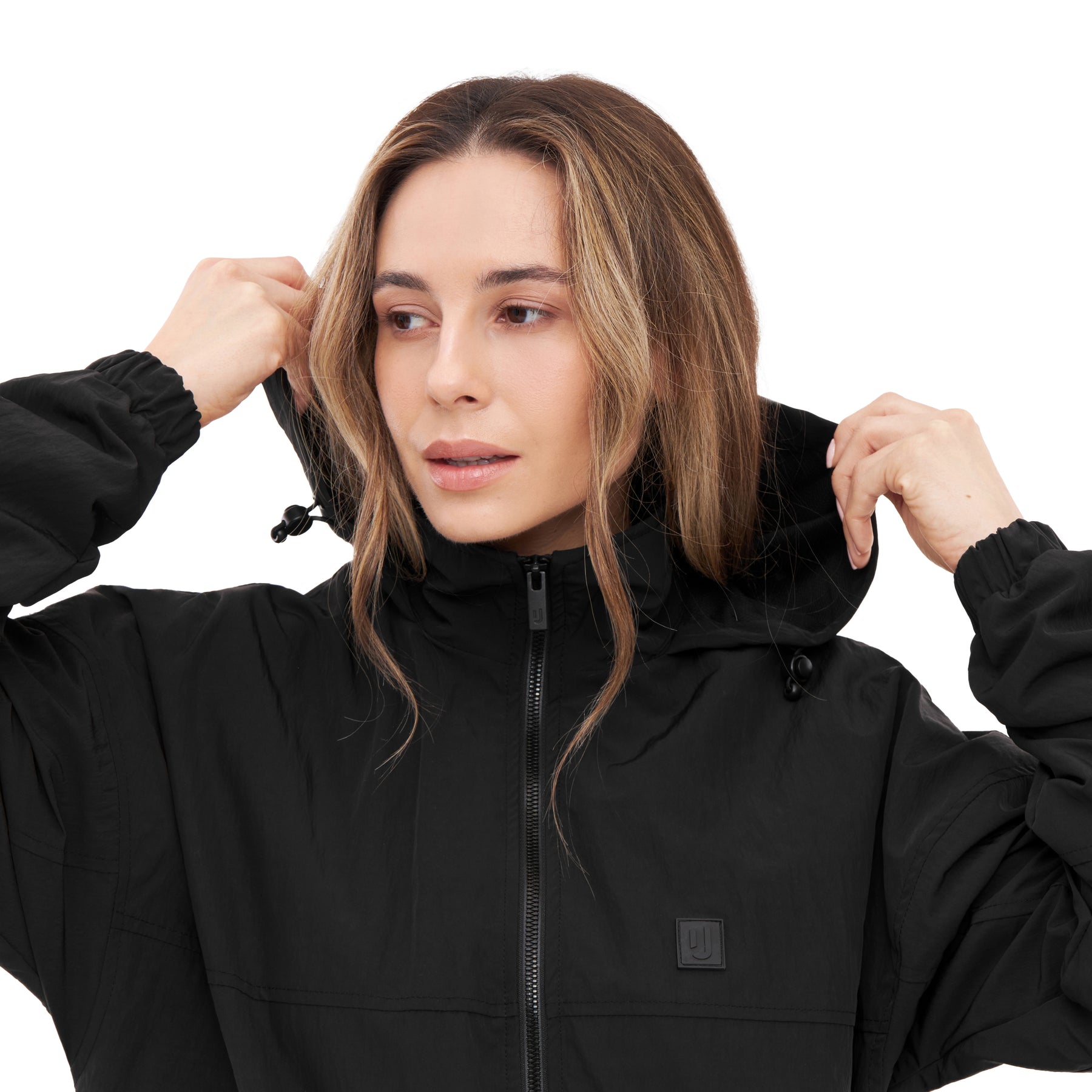 Frau zieht Kapuze der schwarzen Übergangsjacke 'Lennon' an