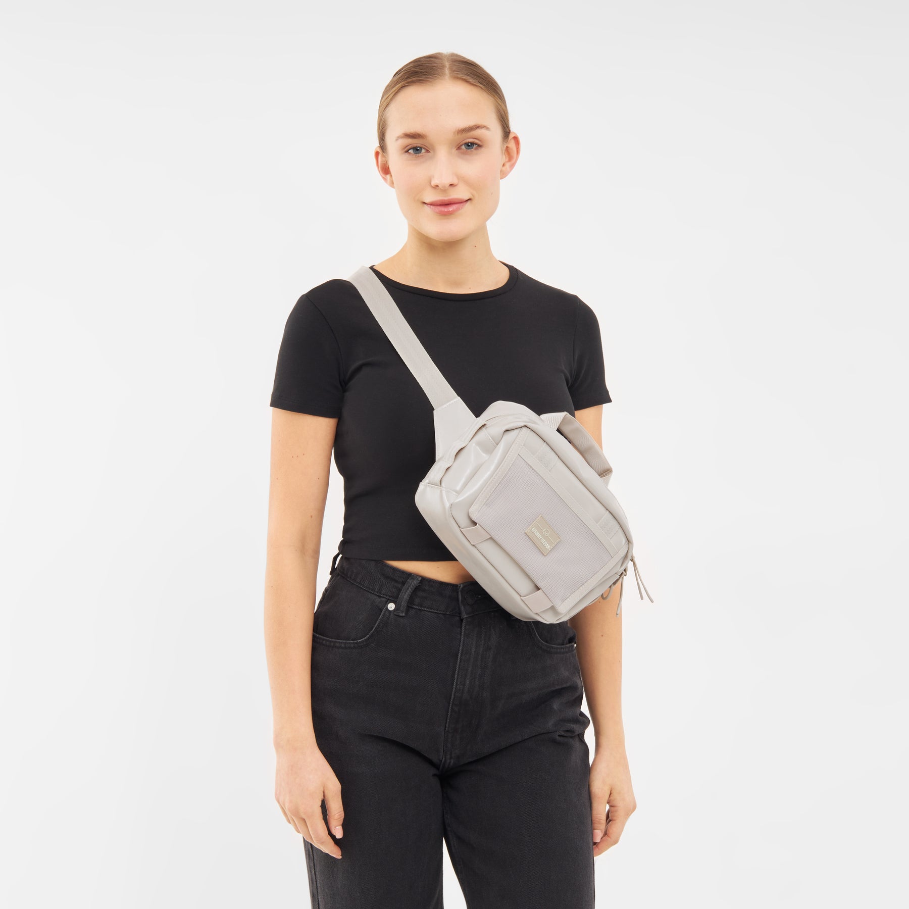 Frau trägt beige Lenkertasche Fahrrad 'Nelson' quer über den Oberkörper, schwarzes T-Shirt und schwarze Hose