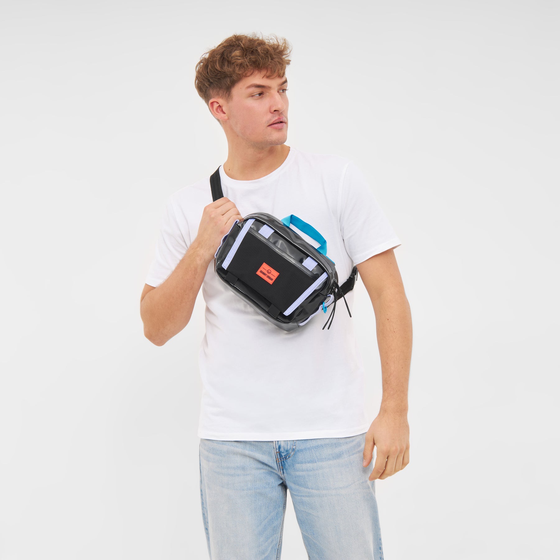 Mann trägt Umhängetasche Lenkertasche Fahrrad 'Nelson' in Schwarz mit blauem Griff und oranger Marke