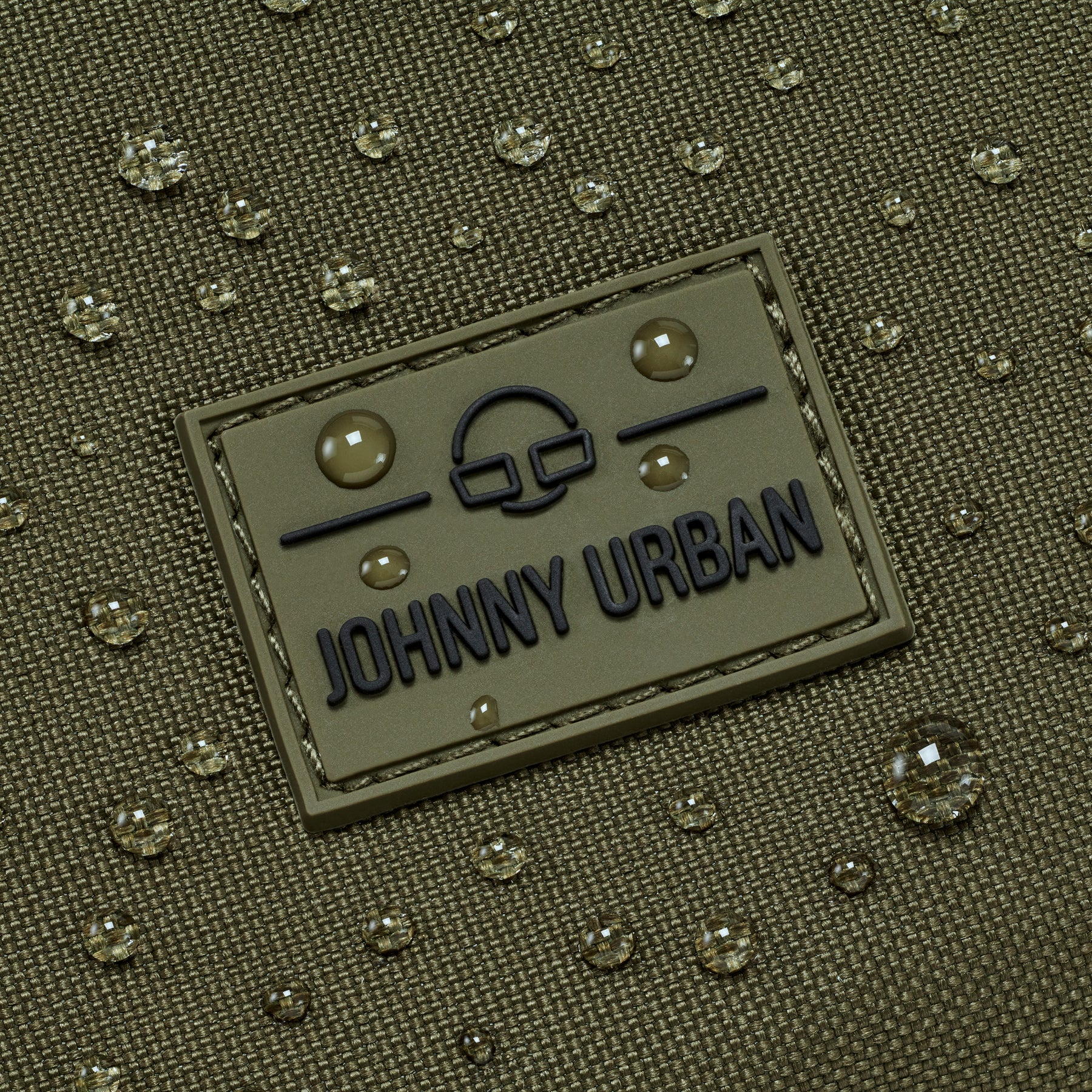 Grünes wasserabweisendes Material mit Johnny Urban Logo und Wassertröpfchen