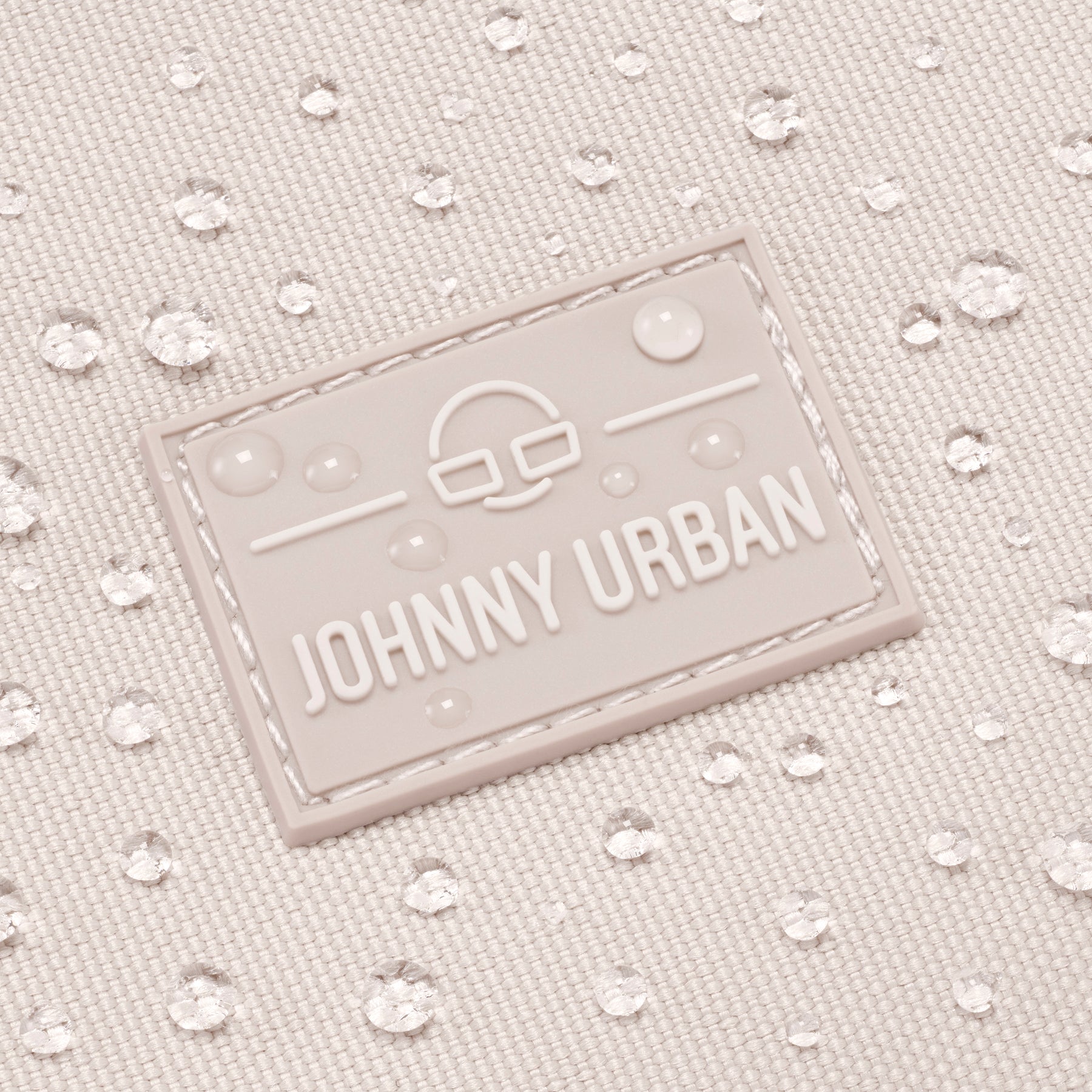 Wasserabweisendes Stoffmaterial der Umhängetasche 'Drew' in Sandfarbe mit JOHNNY URBAN Logo mit Wassertropfen darauf