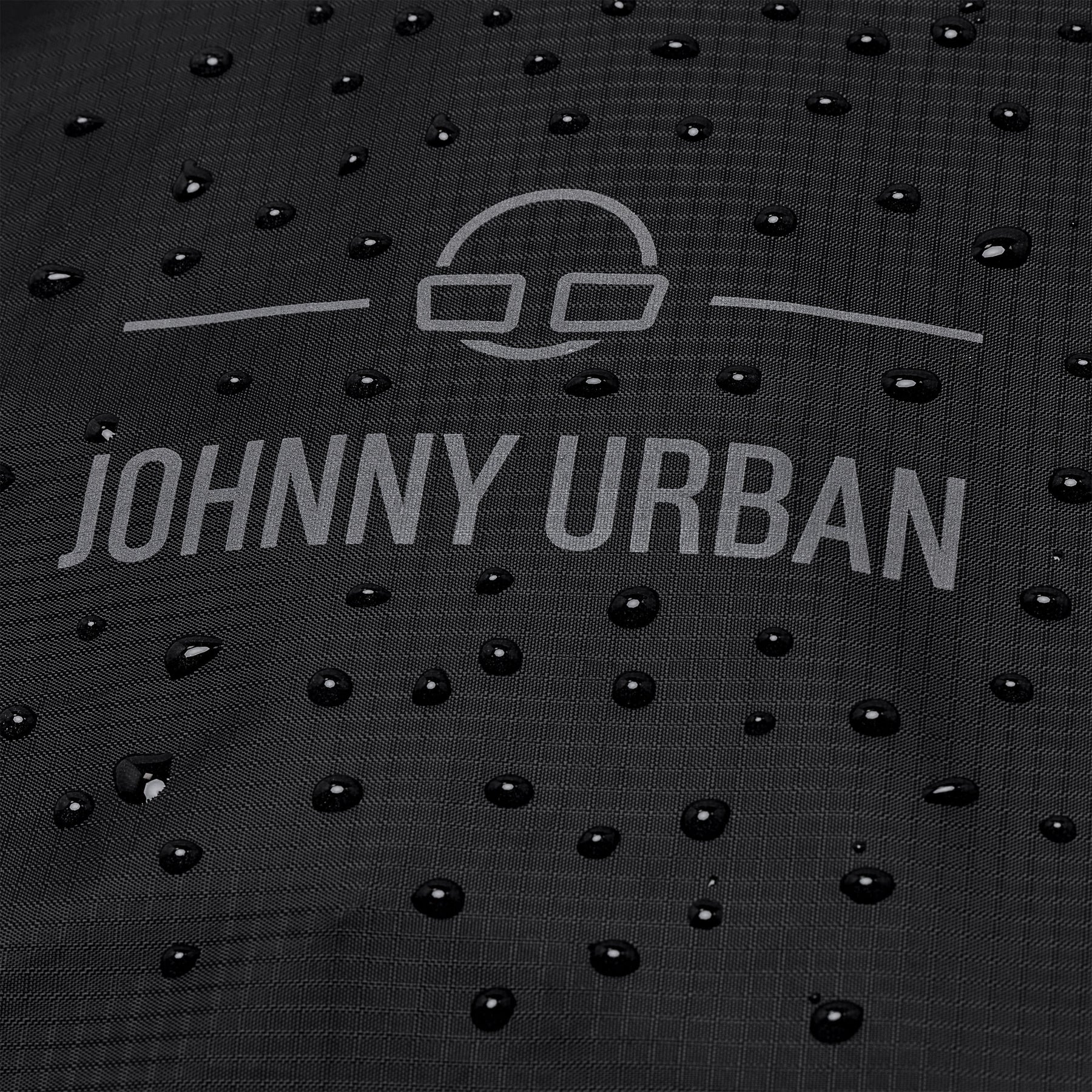 Wasserabweisende schwarze Regenschutzhülle 'Bo XL' von Johnny Urban mit Wassertropfen darauf