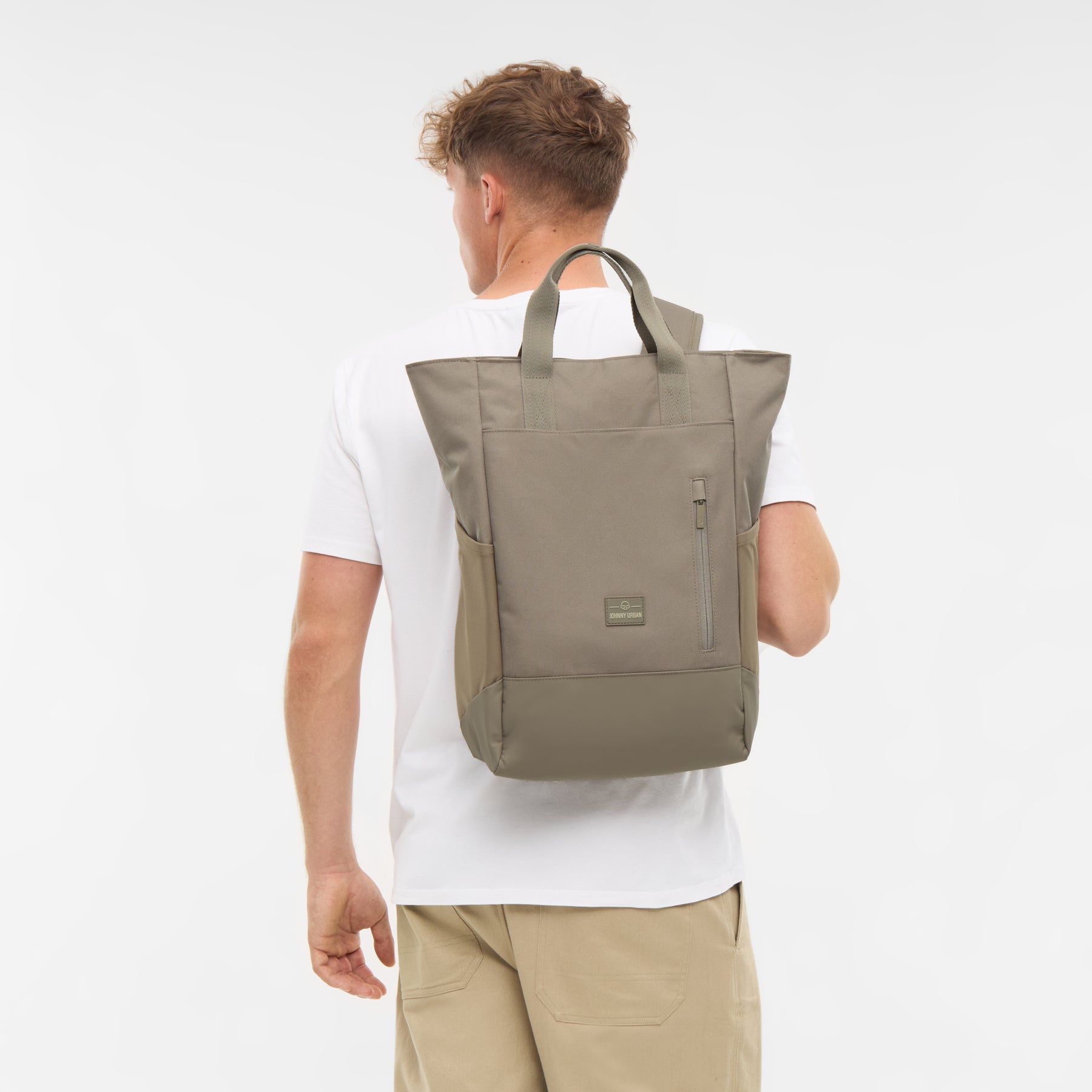 Mann von hinten mit Wickeltasche 'Blair' in Desert Grey, Trageträger und Griffe sichtbar