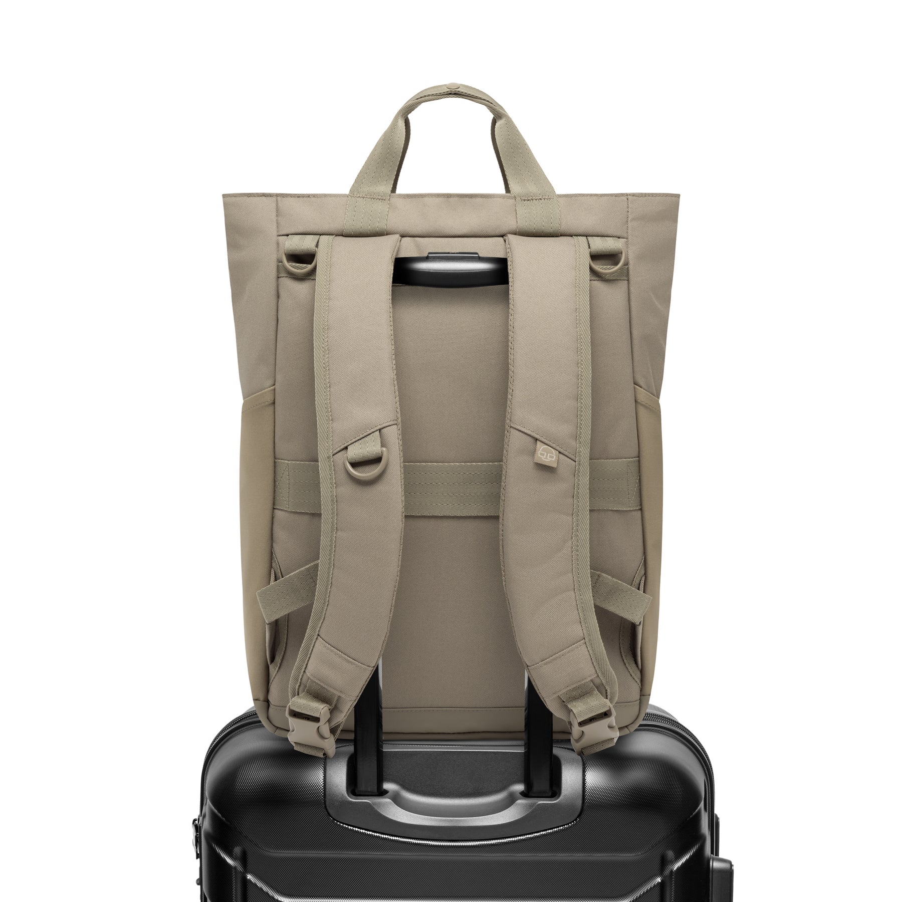 Rückansicht der Wickeltasche 'Blair' in Beige auf einem schwarzen Trolley-Koffer befestigt