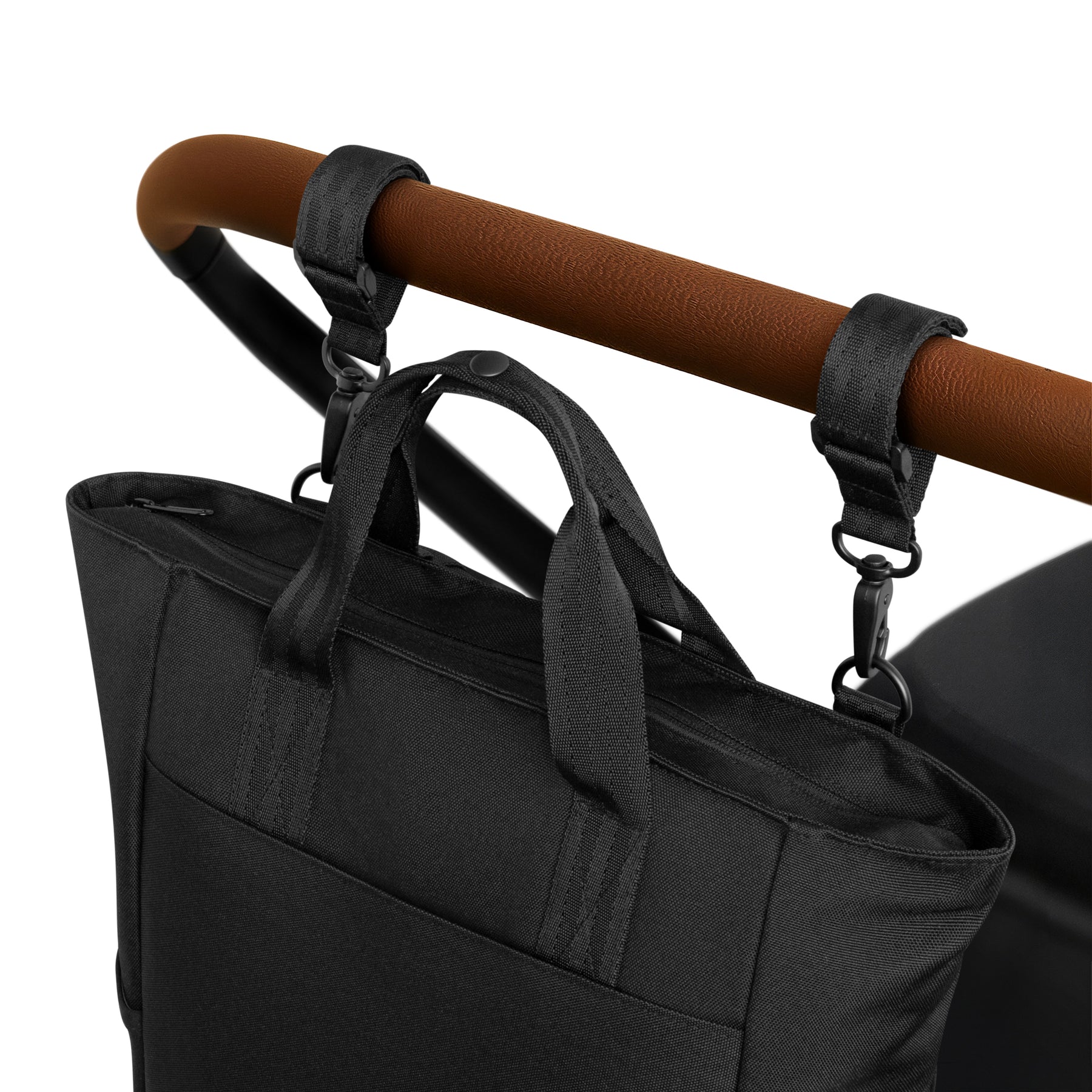Schwarze Wickeltasche 'Blair' aus robustem Material, an braunem Kinderwagen mit zwei schwarzen Gurten befestigt