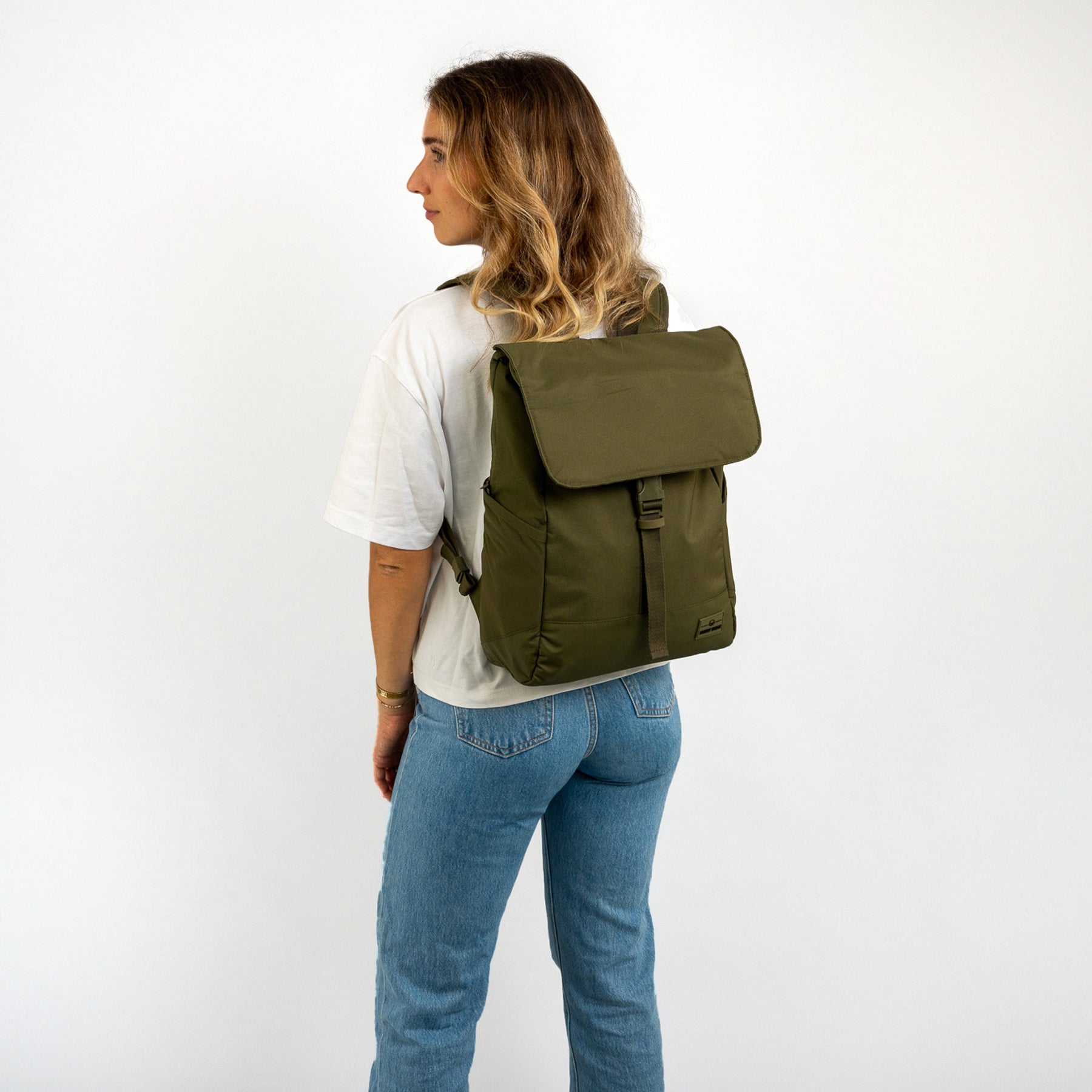 Frau mit olivgrünem Johnny Urban Rucksack 'Mika', trägt weiße T-Shirt und blaue Jeans