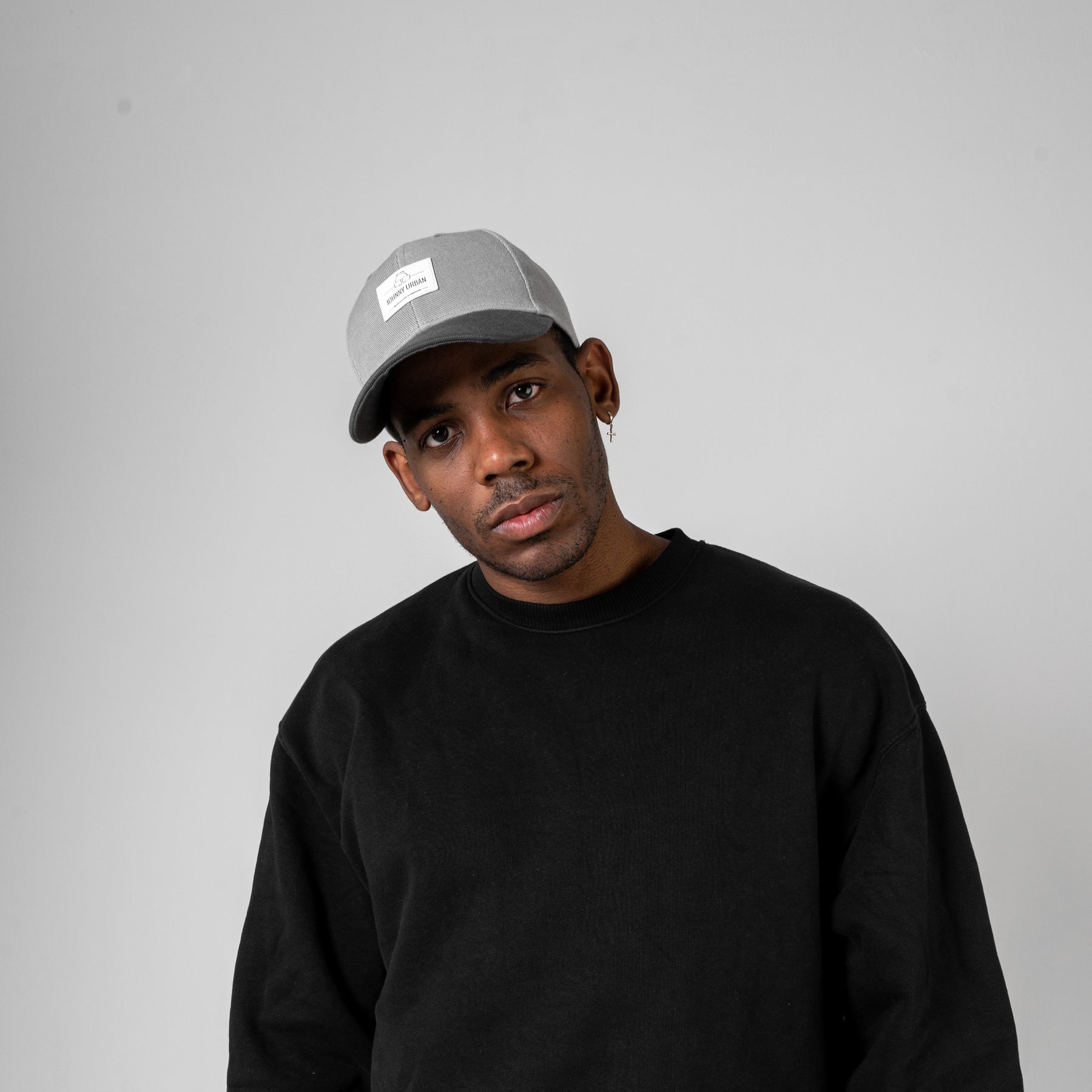 Mann in schwarzem Pullover trägt graue, gewölbte 'Dean' Cap von Johnny Urban