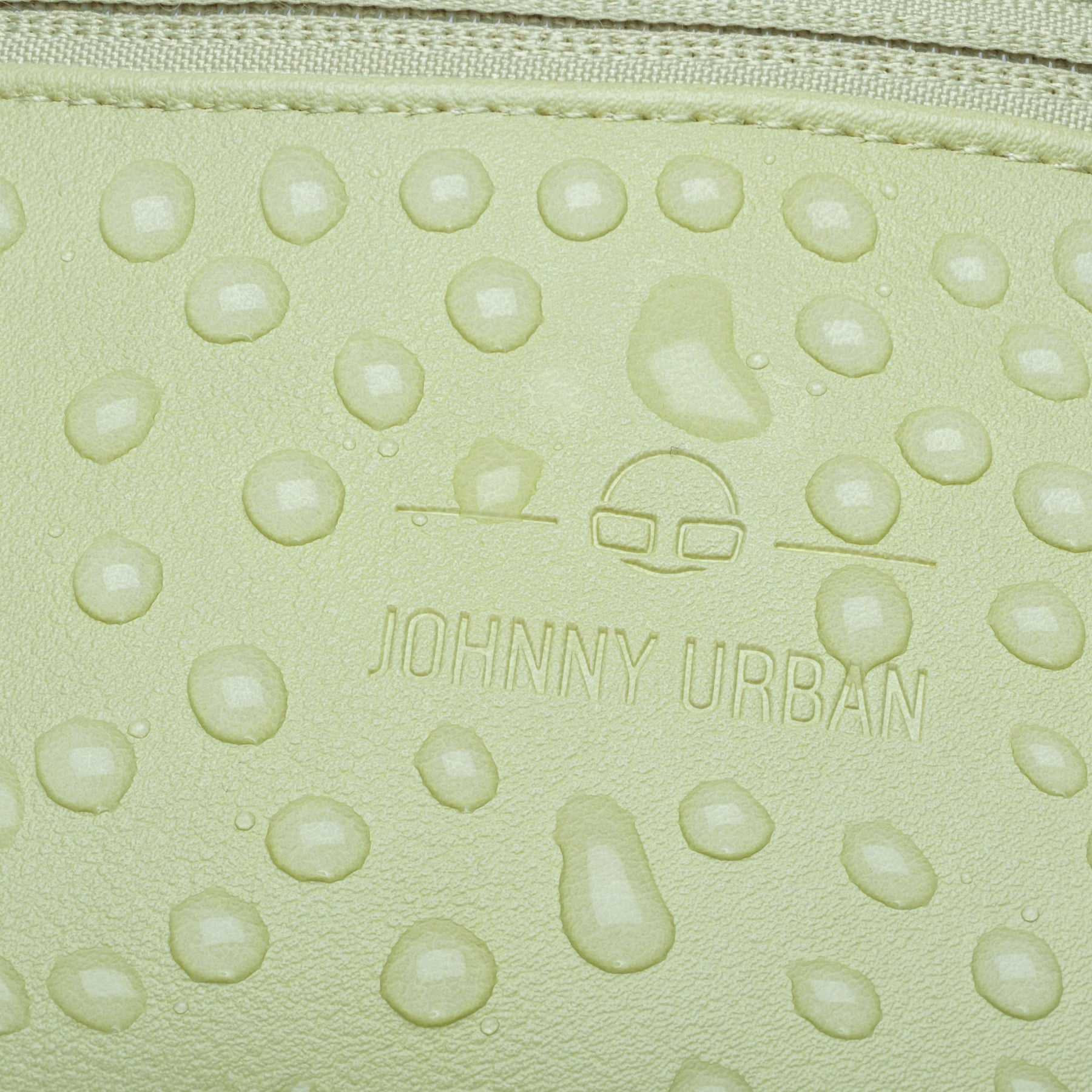 Nahaufnahme wasserabweisender Kunstlederoberfläche der limefarbenen Bauchtasche 'Toni' mit Johnny Urban Logo