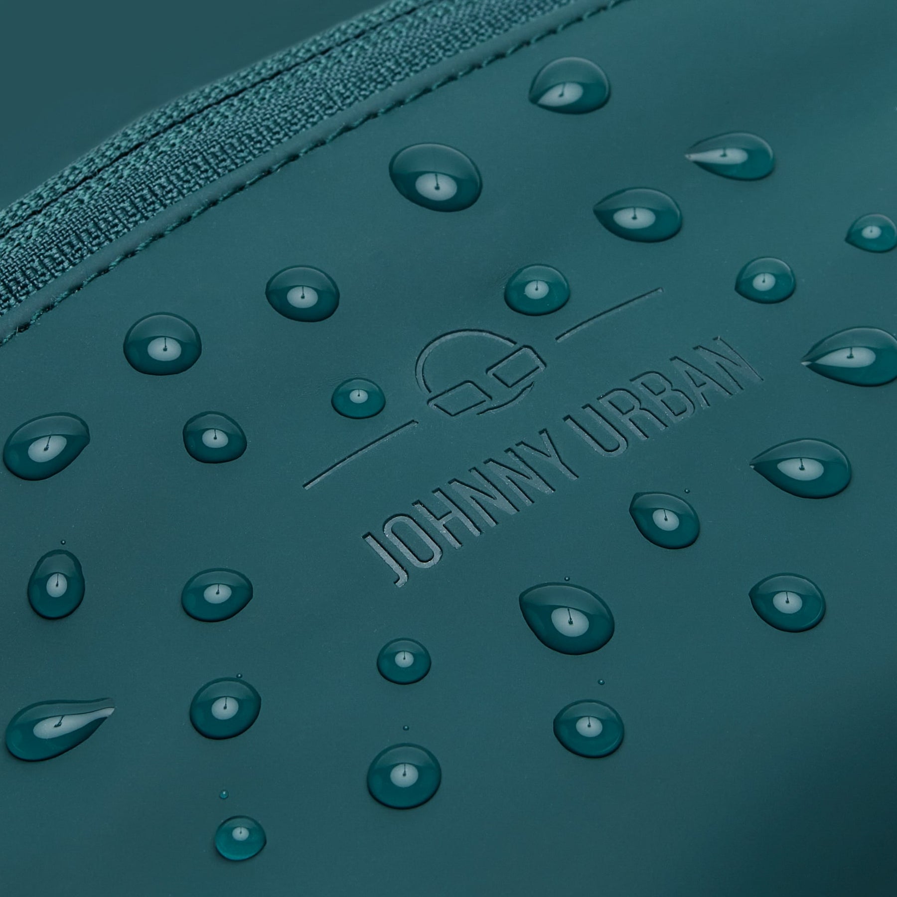 Detailaufnahme der wasserabweisenden petrolgrünen Bauchtasche 'Riley' von Johnny Urban mit Wassertropfen
