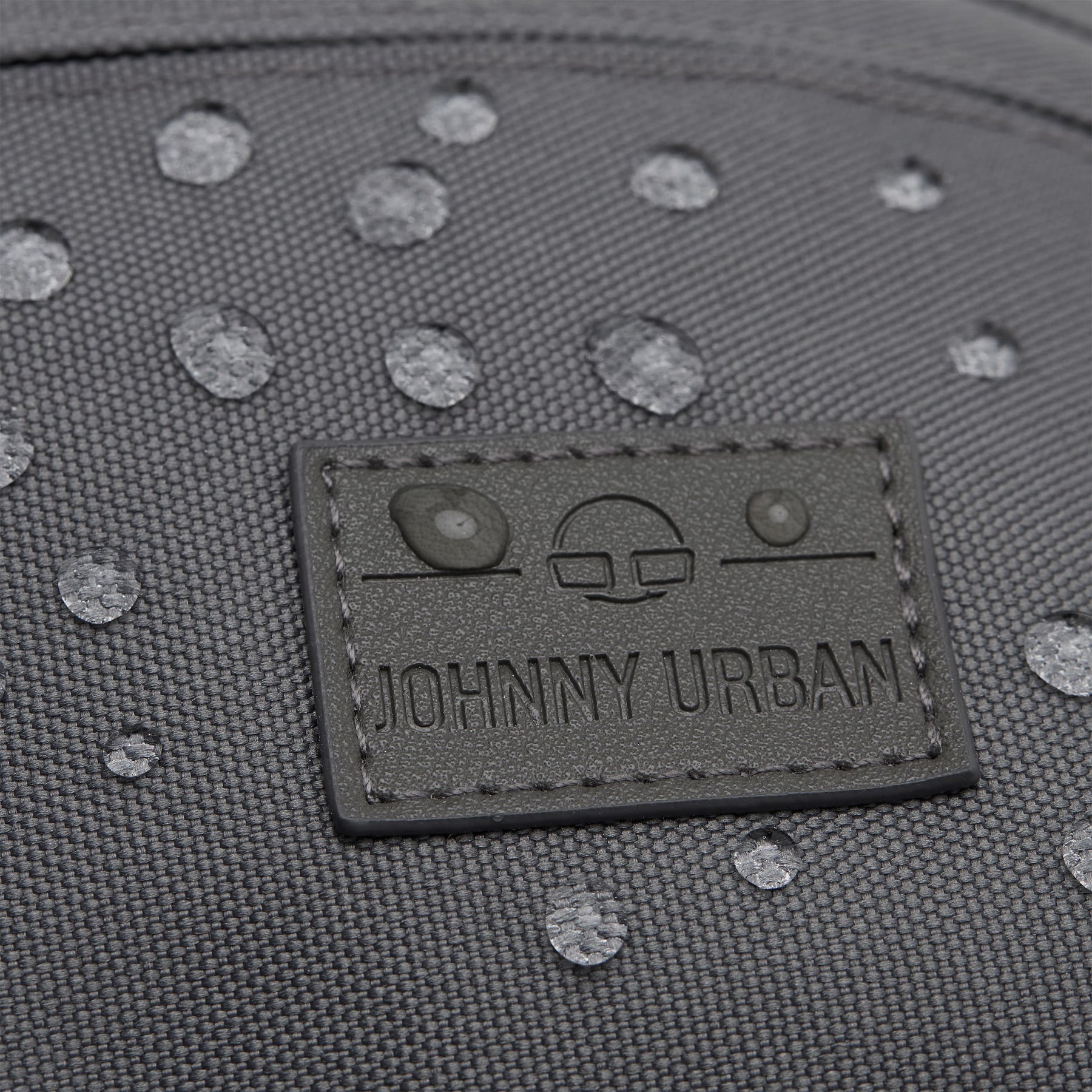 Wasserdichte graue Bauchtasche 'Tom' mit Johnny Urban Logo und sichtbaren Wassertropfen auf der Oberfläche