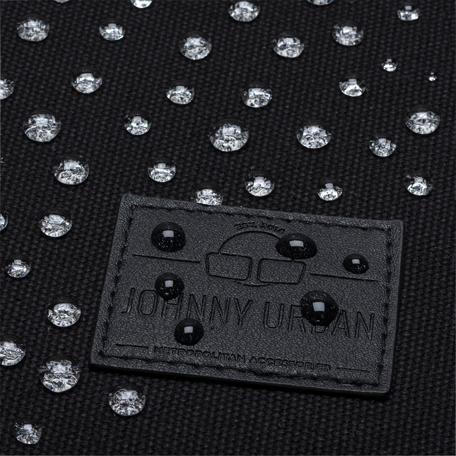 Wasserabweisendes schwarzes Canvas-Material mit Johnny Urban Label und Wassertropfen