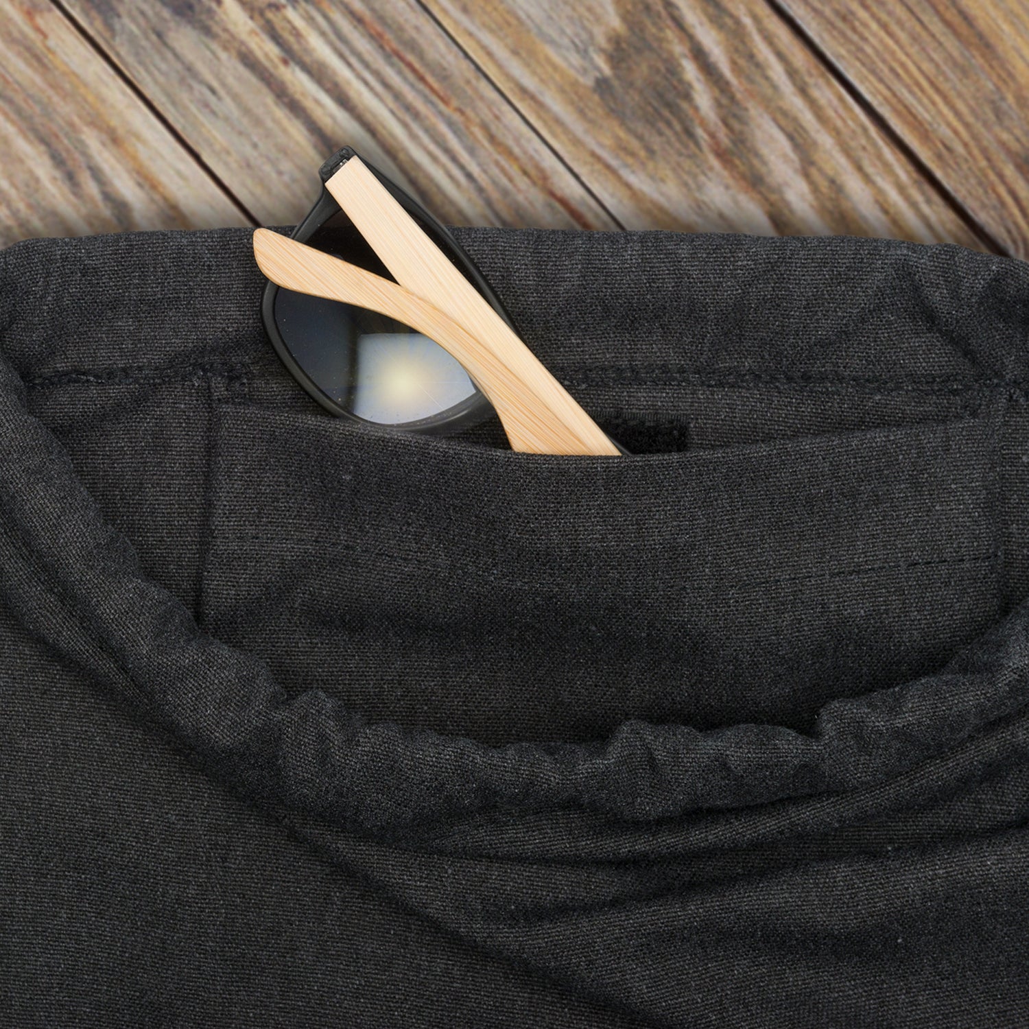 Schwarzer Canvas-Turnbeutel 'Luke' mit sichtbarer Außentasche und teilweise herausragender Brille mit hellen Bügeln