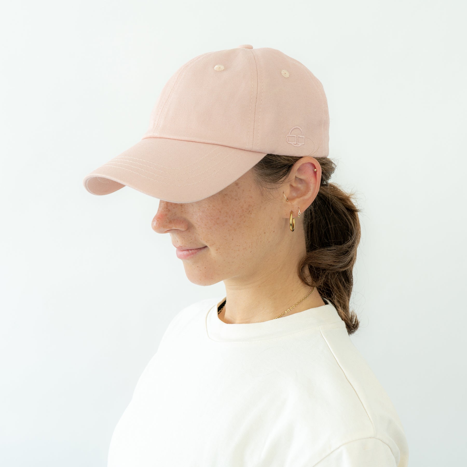 Frau mit rosa Cap 'Jen' von Johnny Urban, seitlich gesehen, getragen zu weißem Oberteil