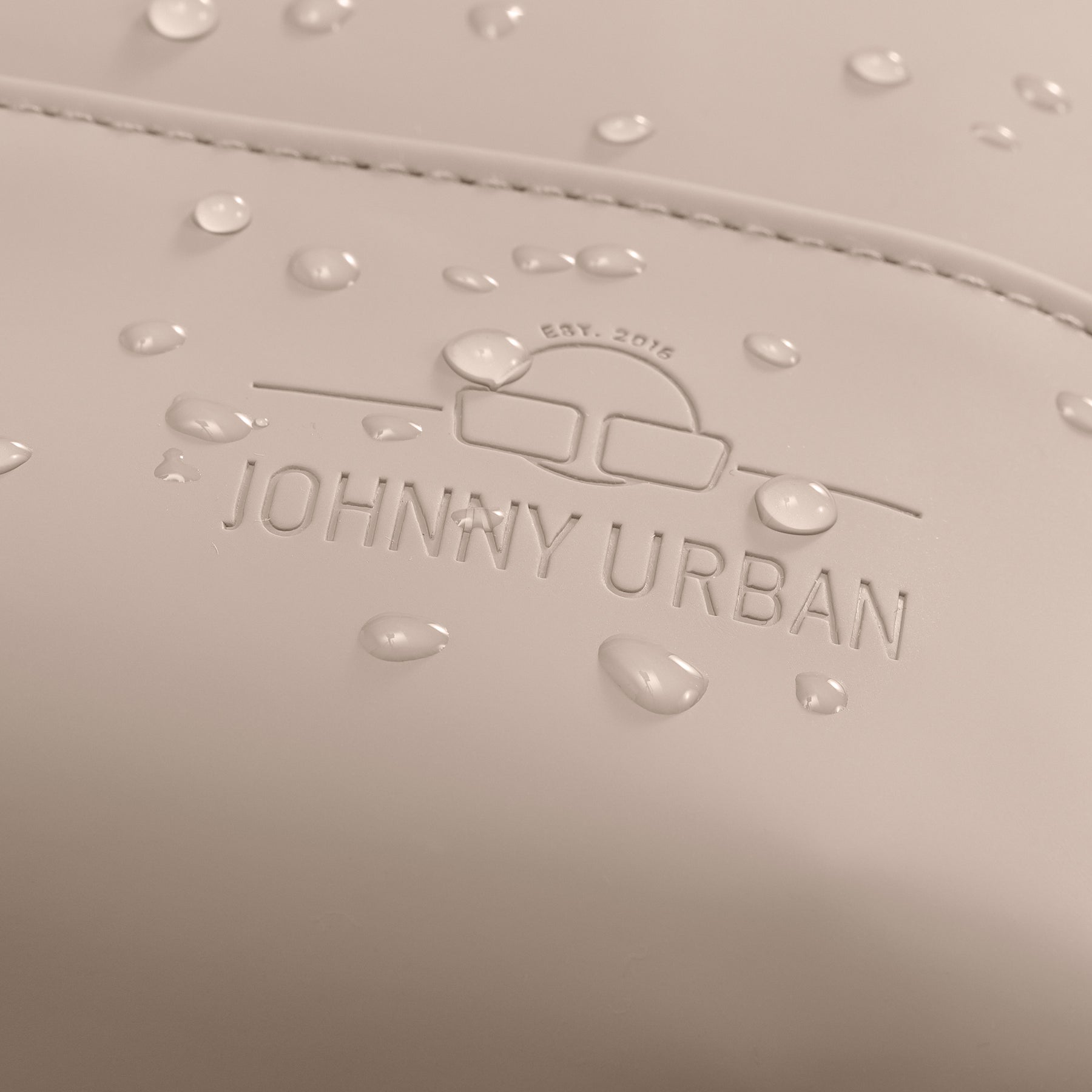 Wasserabweisende Oberfläche eines hellbeigen Damenrucksacks 'Ruby' von Johnny Urban mit geprägtem Logo