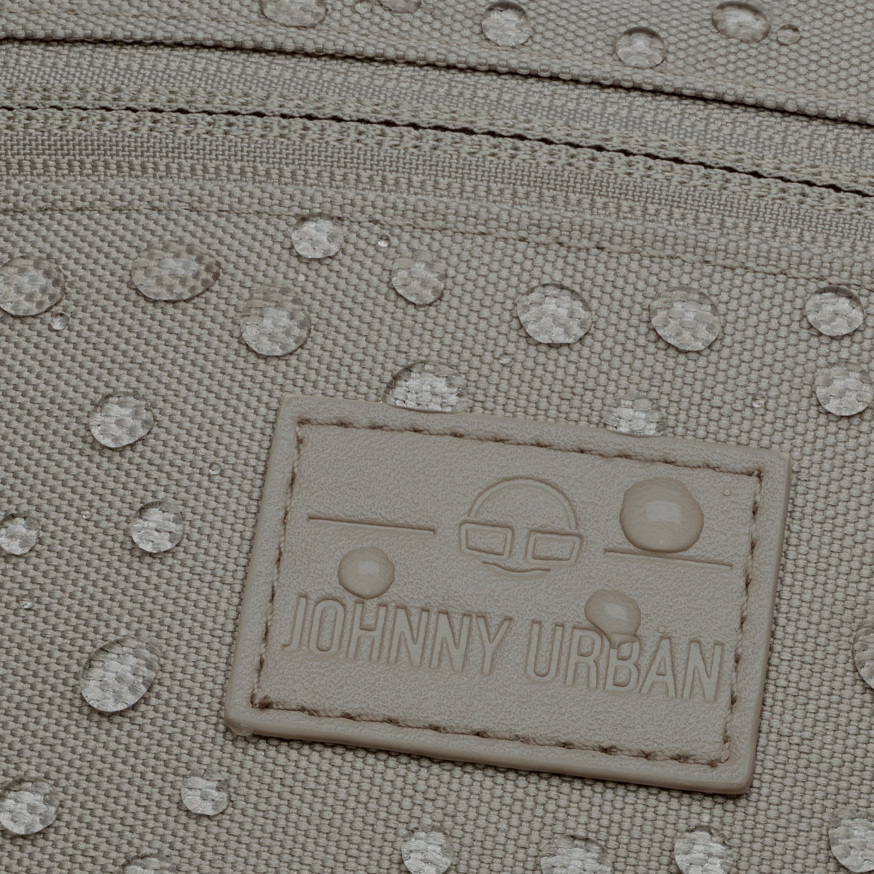 Nahaufnahme der wasserabweisenden Oberfläche und des Johnny Urban Logos auf der Bauchtasche 'Erik Small' in desert grey