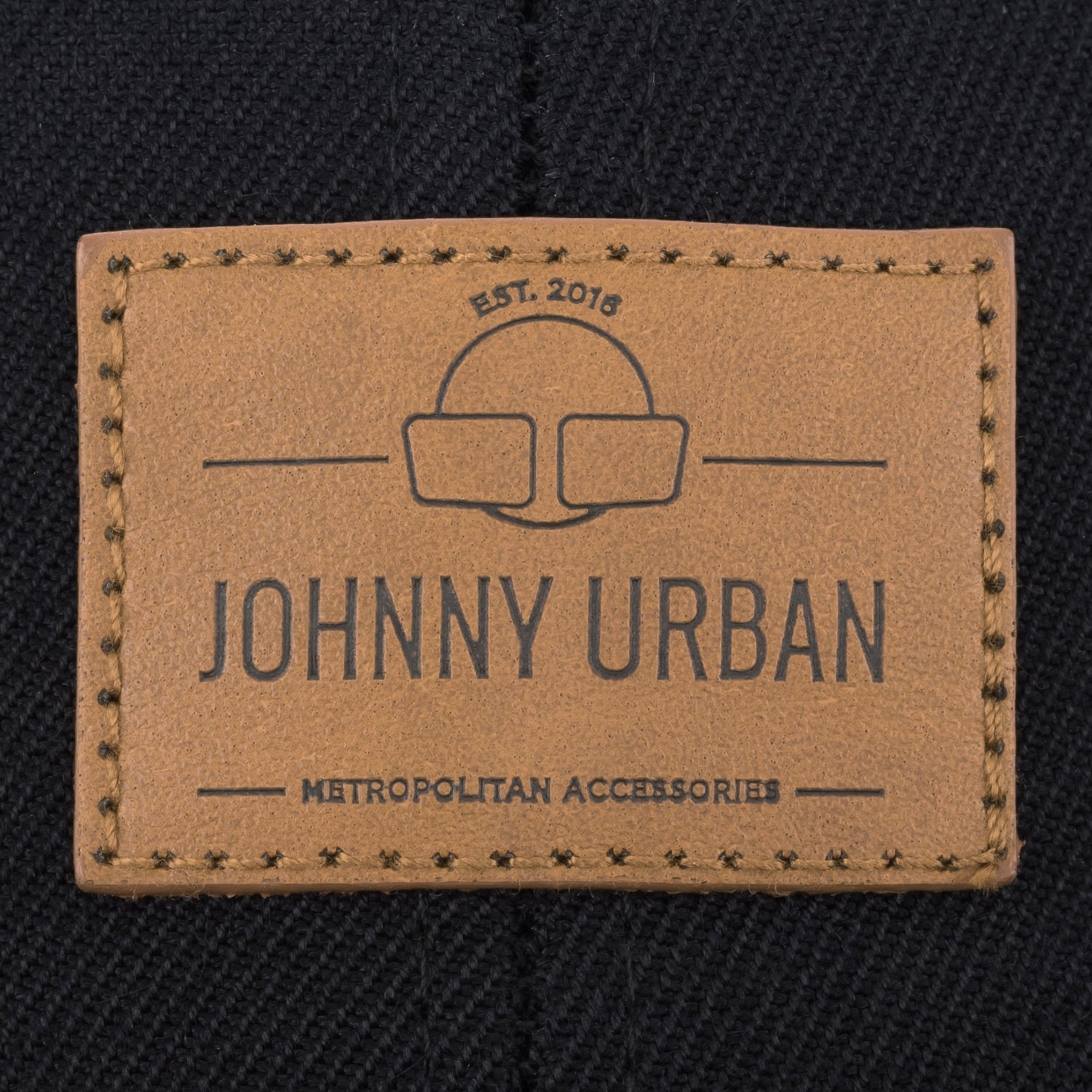 Braunes Johnny Urban Lederetikett mit Prägung auf schwarzem Stoff