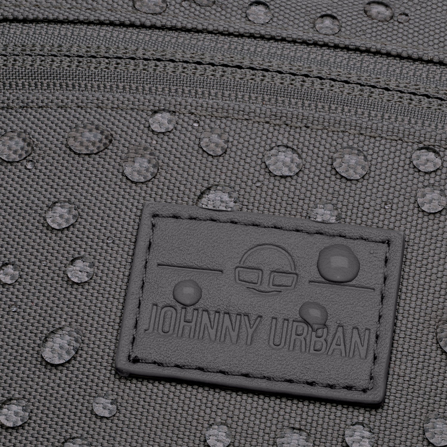 Nahaufnahme der wasserabweisenden, dunkelgrauen Bauchtasche 'Erik Small' von Johnny Urban mit sichtbaren Wassertropfen