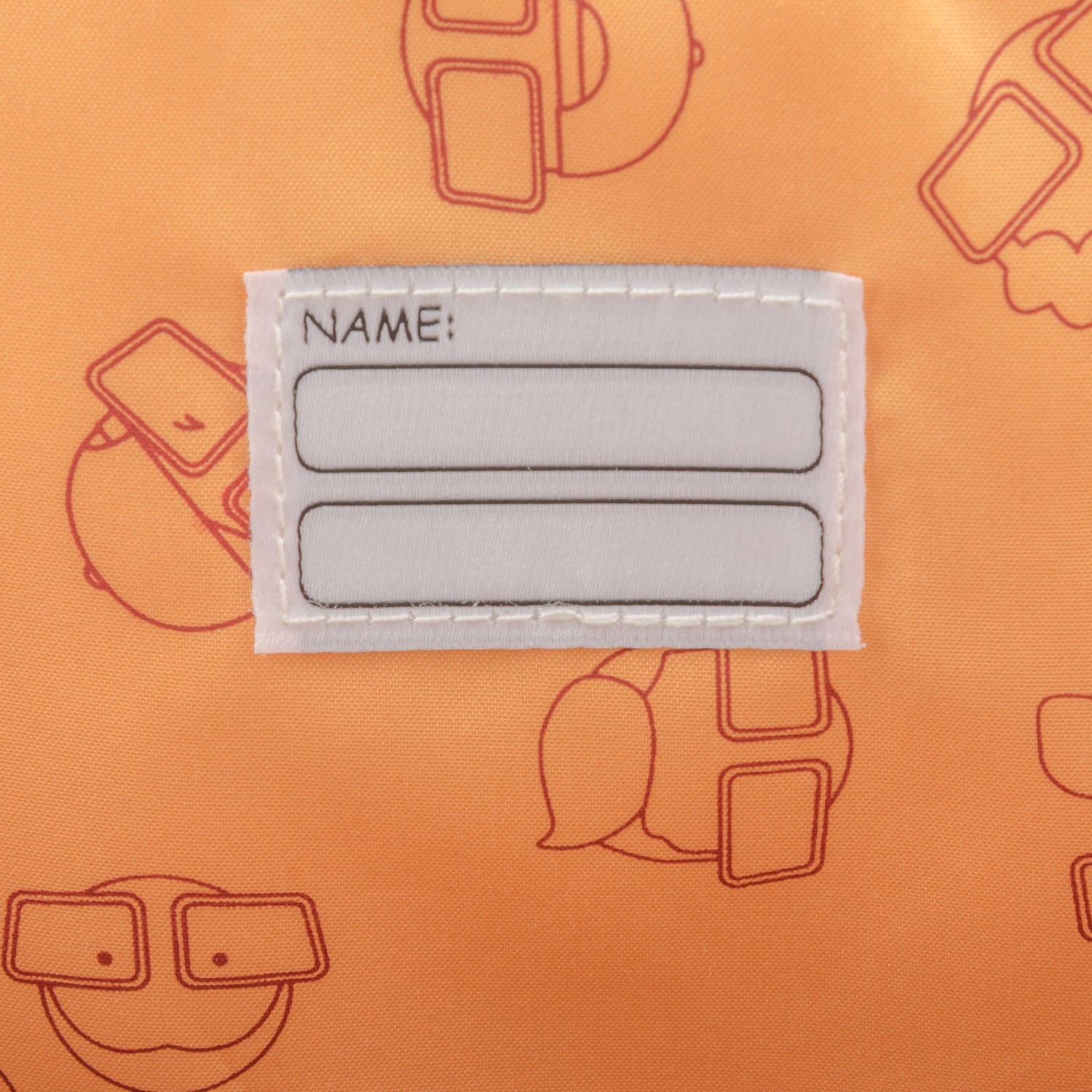 Namensschild mit zwei leeren Feldern auf orangem Kinderrucksack "Linus" mit Muster aus Comicgesichtern