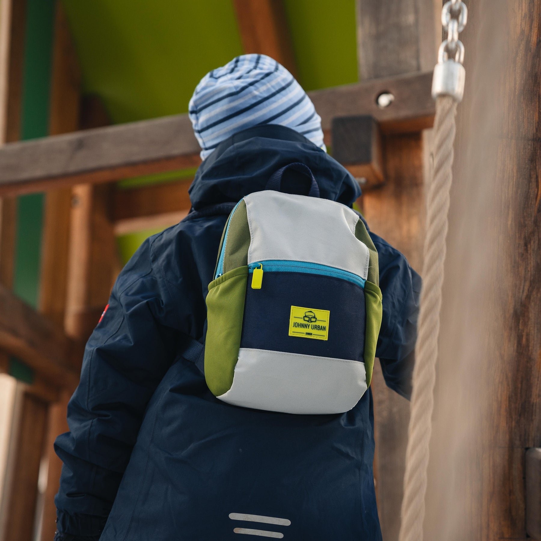 Kind trägt Kinderrucksack 'Leo' von Johnny Urban in Blau, Olivgrün und Grau auf dem Rücken
