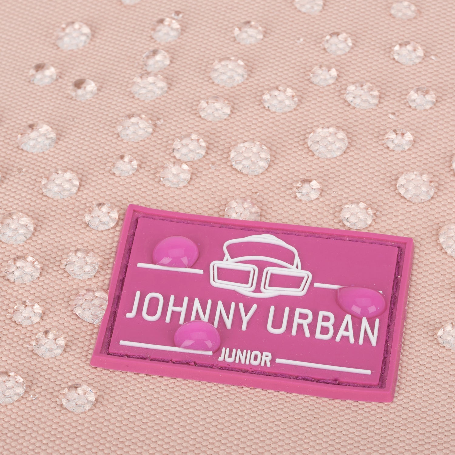 Nahaufnahme eines rosa wasserdichten Rolltop-Kinderrucksacks 'Aaron' mit 'Johnny Urban Junior'-Logo