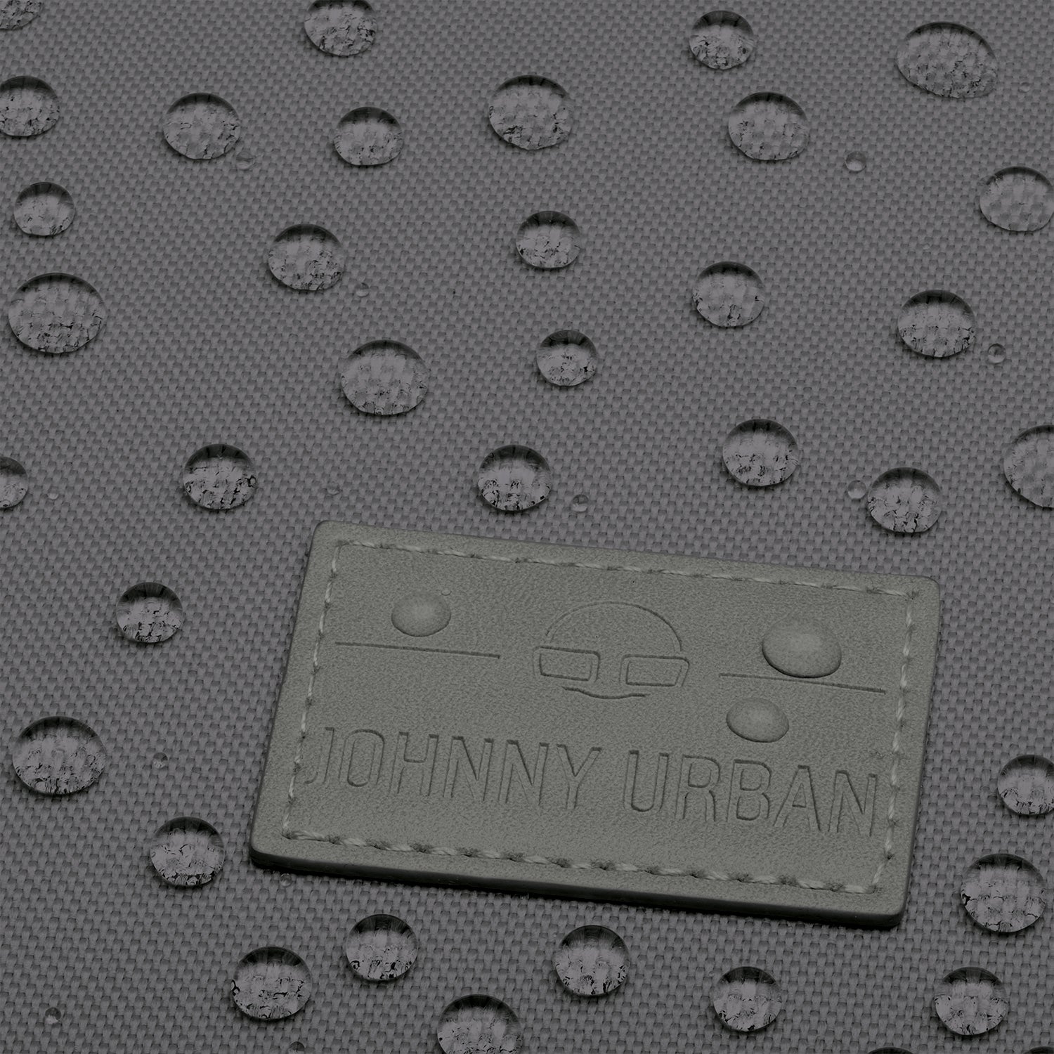 Nahaufnahme des dunkelgrauen Johnny Urban Rolltop Rucksacks mit wasserabweisender Textur und Wassertropfen