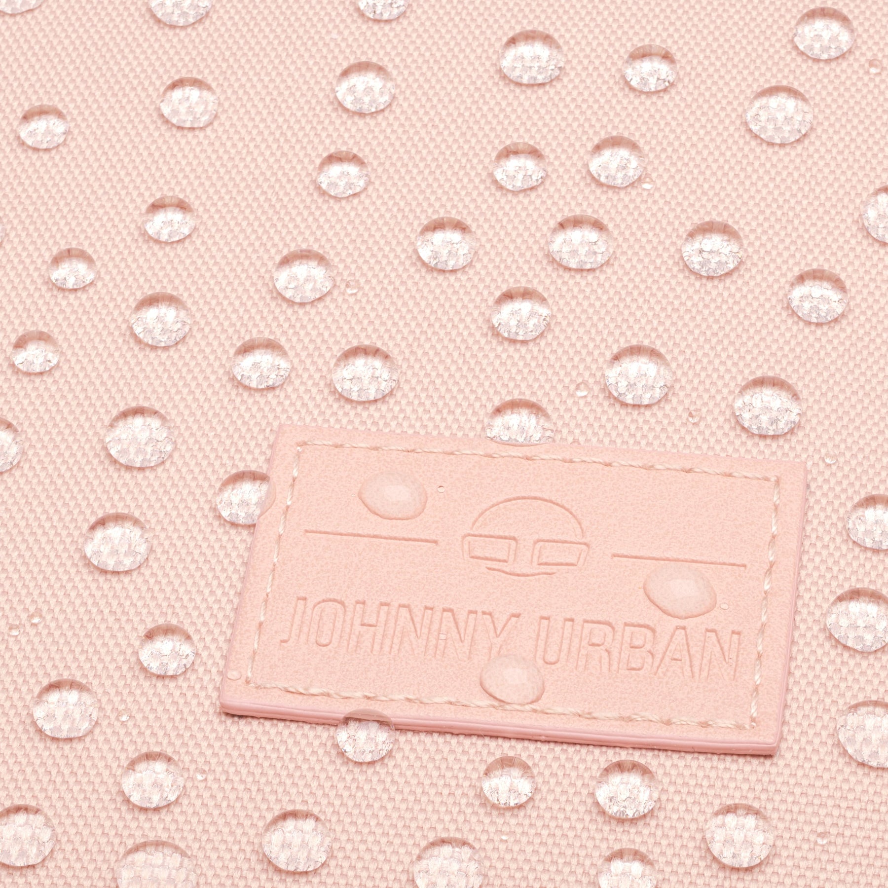 Wasserabweisender rosa Stoff mit Johnny Urban Markenlogo auf einem Rolltop Rucksack