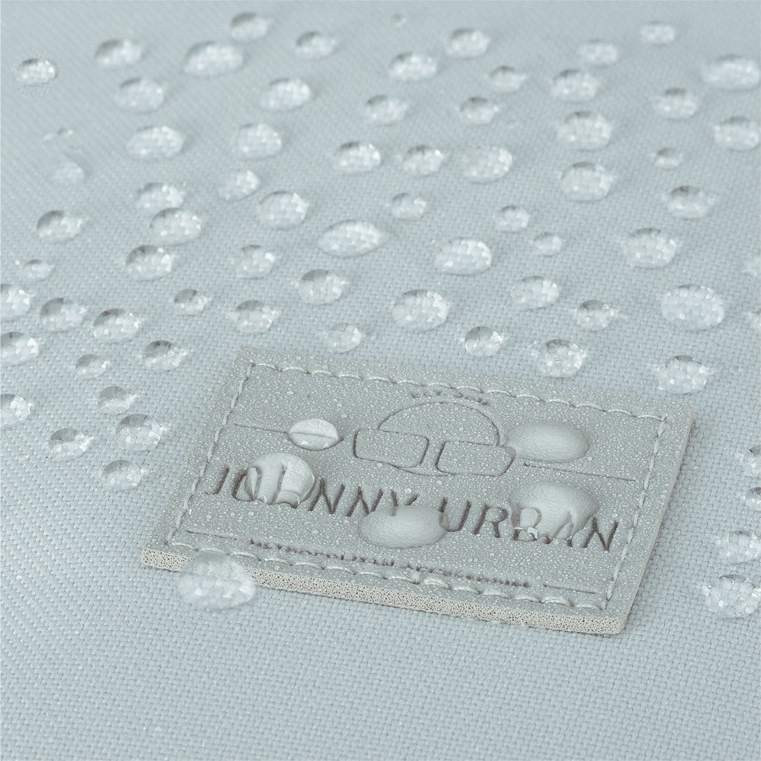 Nahaufnahme des wasserabweisenden Materials mit Johnny Urban Markenetikett des Rolltop Rucksacks 'Robin Large'