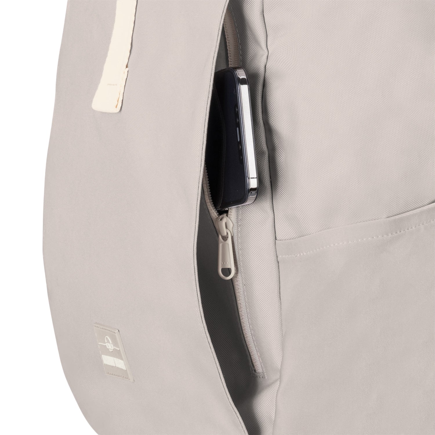 Beiger Rolltop Rucksack Allen XL mit seitlicher Reißverschlusstasche, darin teilweise sichtbares Smartphone