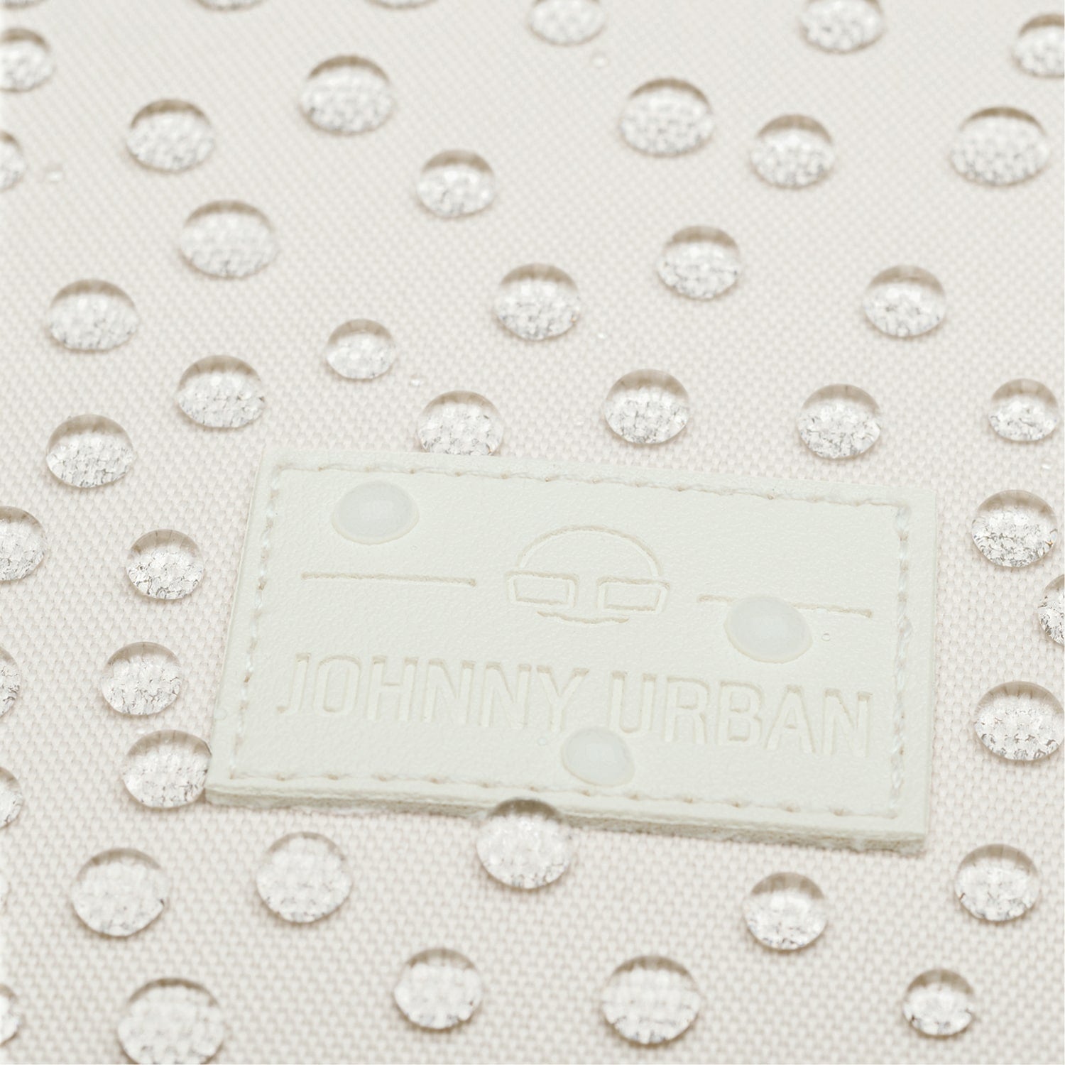 Nahaufnahme des weißen, wasserabweisenden Rolltop Rucksacks "Robin Small" mit Johnny Urban Logo und Wasserperlen auf der Oberfläche