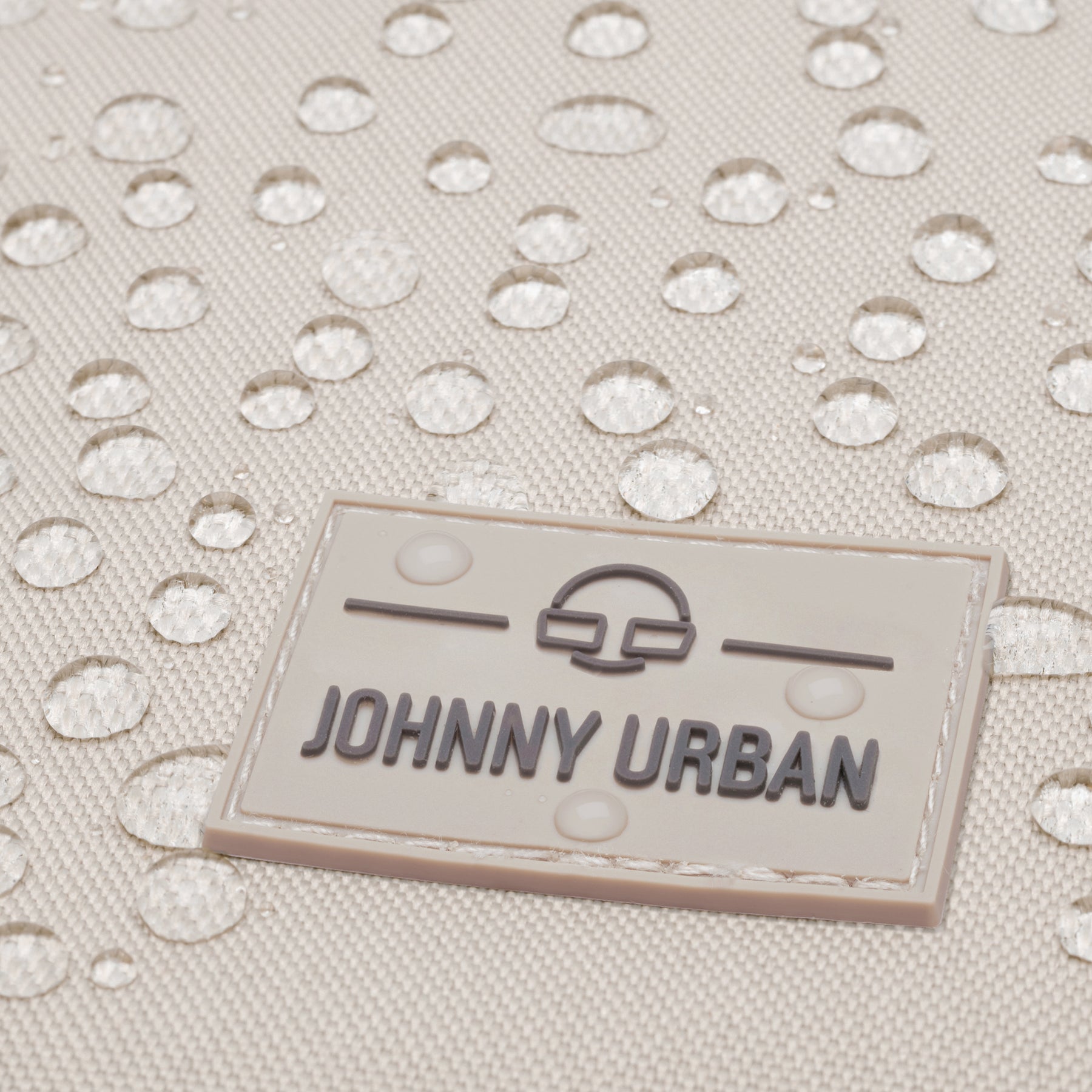 Beiger wasserabweisender Stoff mit Johnny Urban Logo und sichtbaren Wassertröpfchen