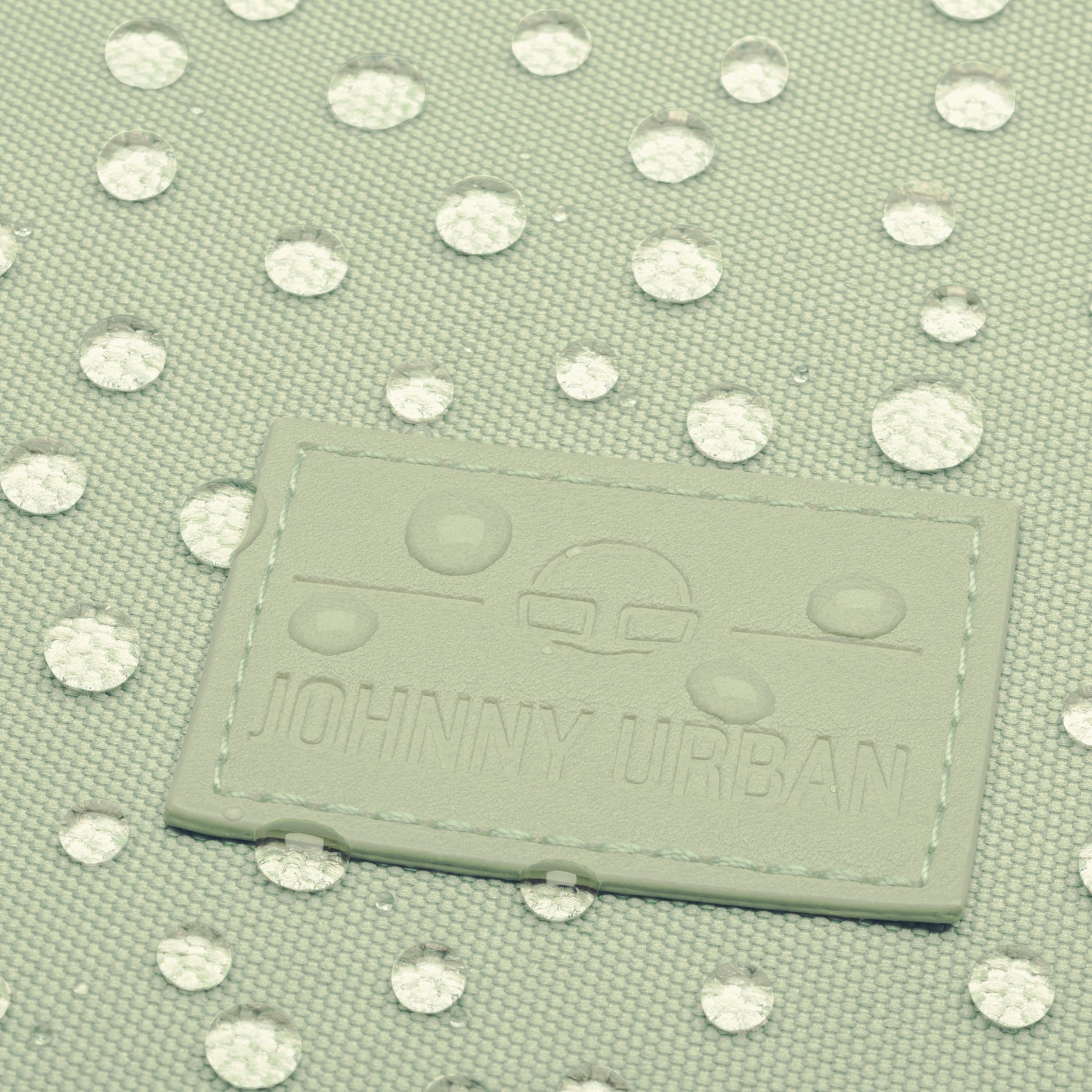 Nahaufnahme des limefarbenen Johnny Urban Rolltop Rucksacks mit wasserabweisenden Wassertropfen