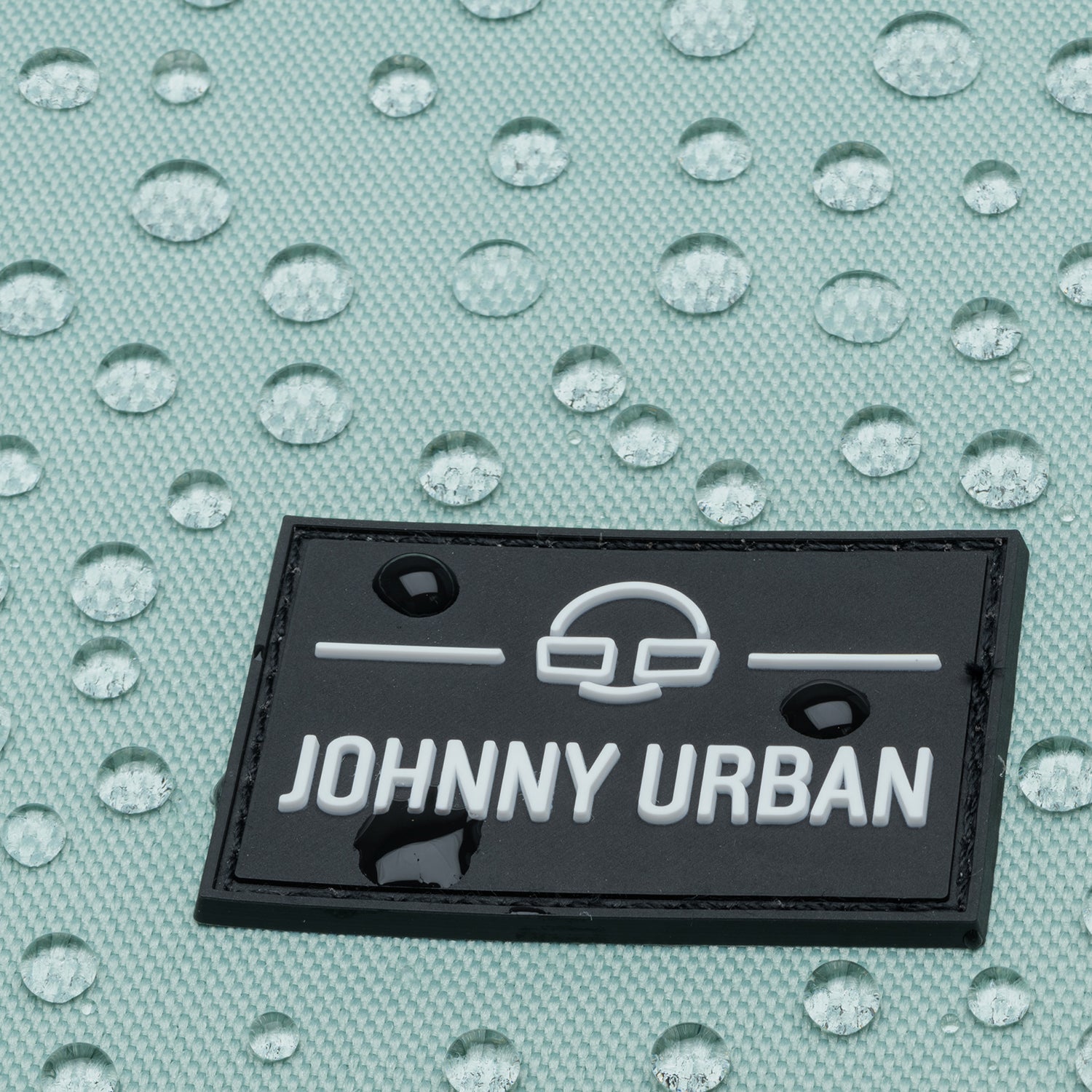 Wasserabweisender mintfarbener Stoff mit Johnny Urban Logo aus schwarzem Material und weißen Buchstaben