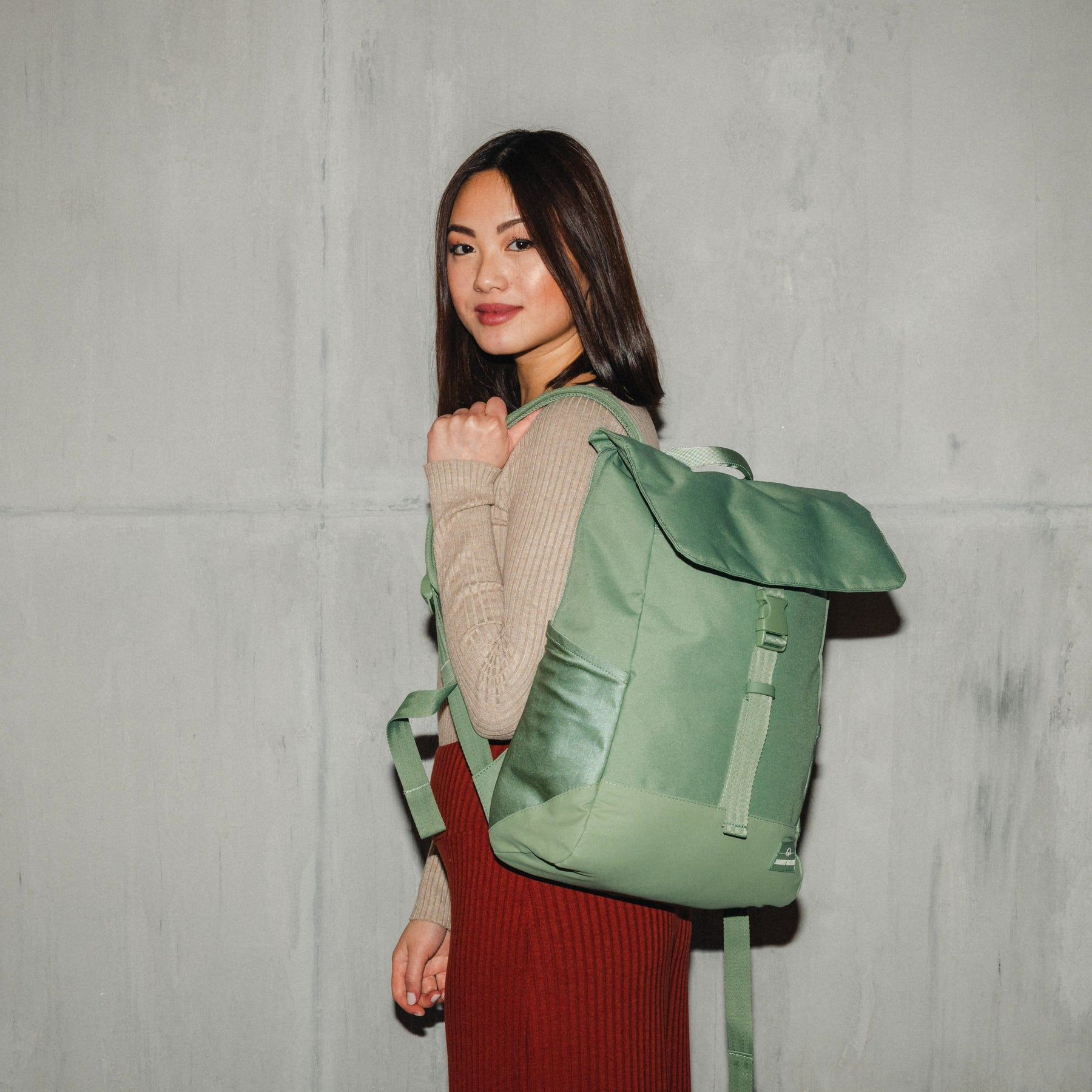 Frau trägt nachhaltigen grünen Rucksack 'Mika' von Johnny Urban mit Klappe und Schnalle