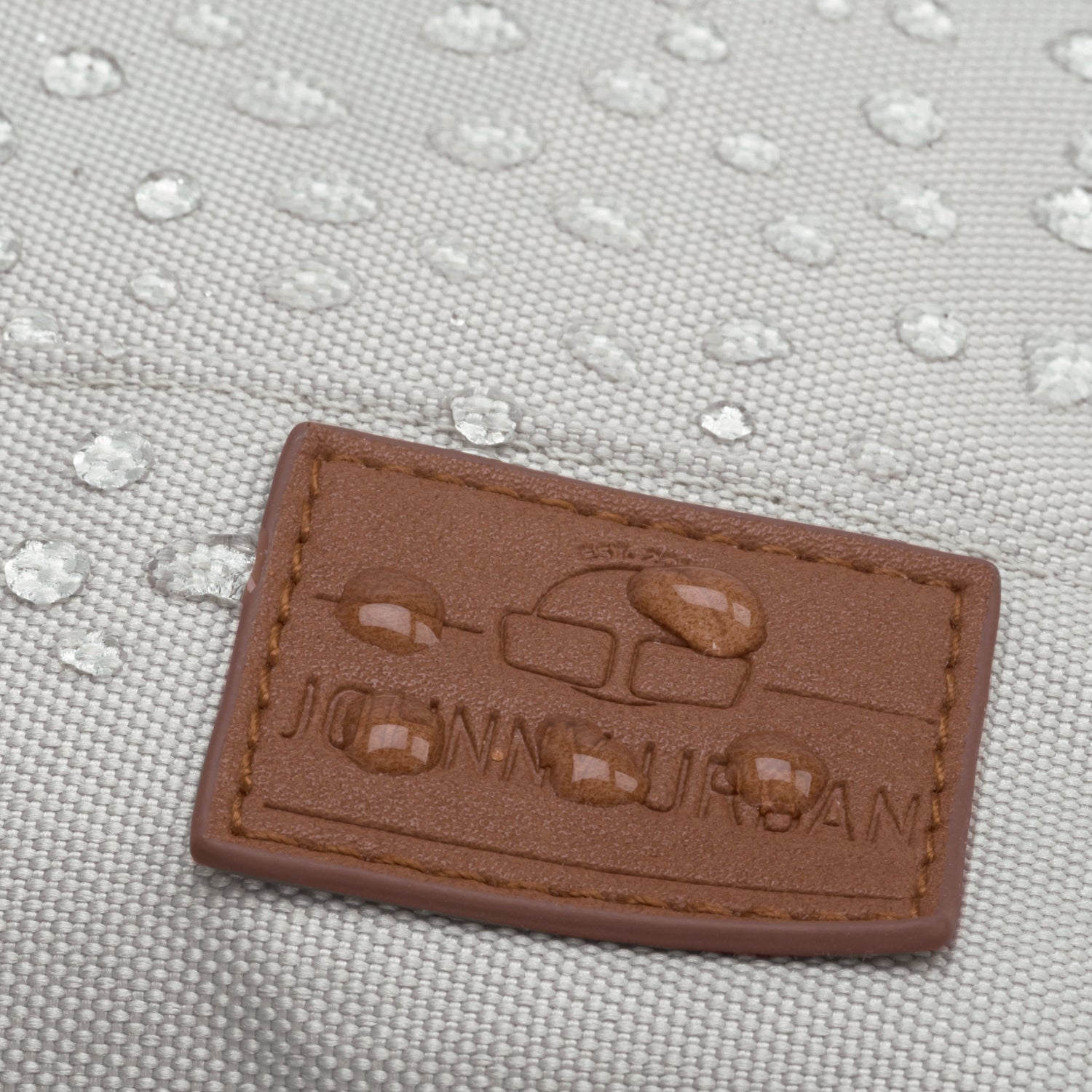 Wasserabweisender beiger Rucksack 'Mia' mit braunem Johnny Urban Logo-Patch und Wassertröpfchen darauf