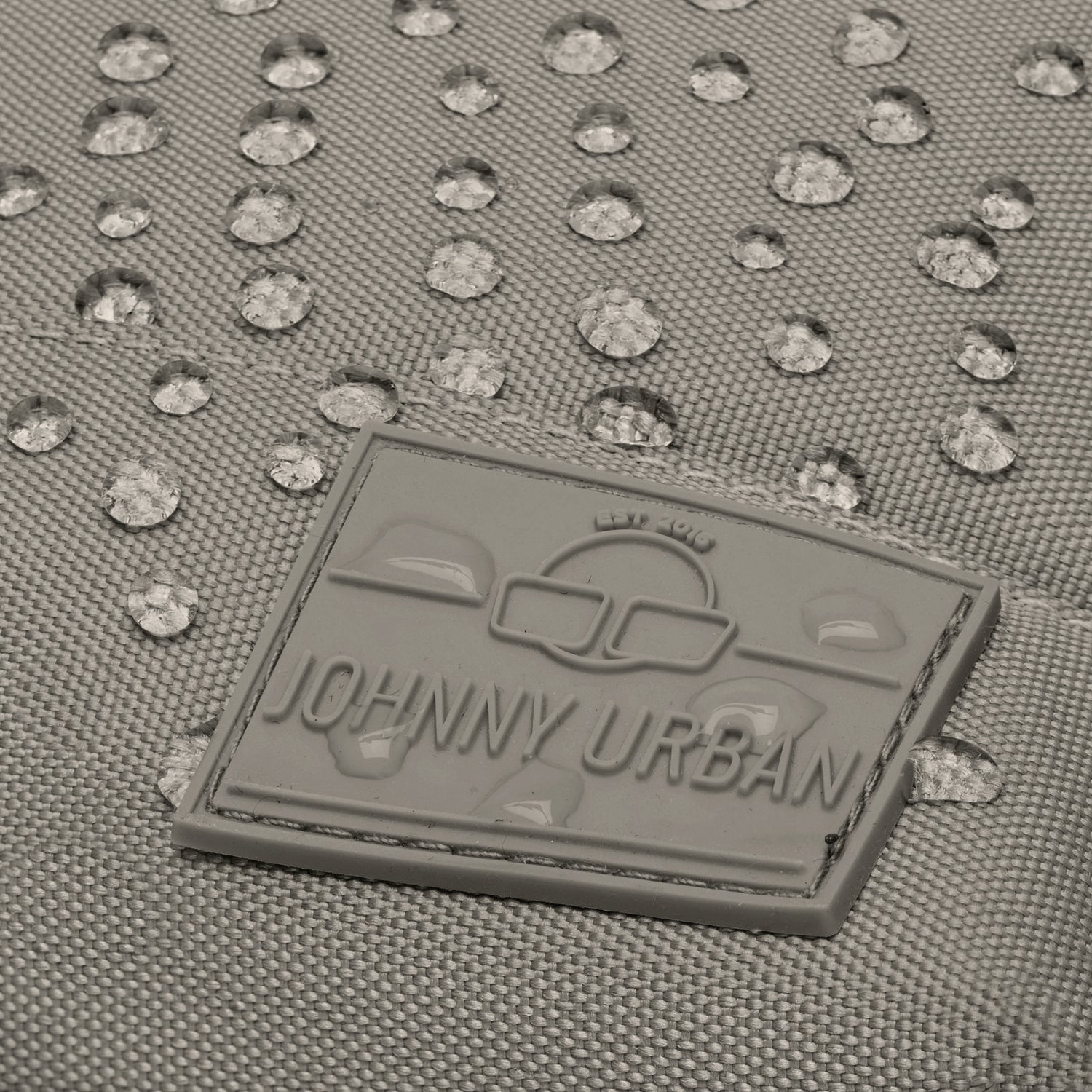 Nahe Aufnahme des wasserabweisenden Materials und des grauen Johnny Urban Logos am Damenrucksack 'Mia'