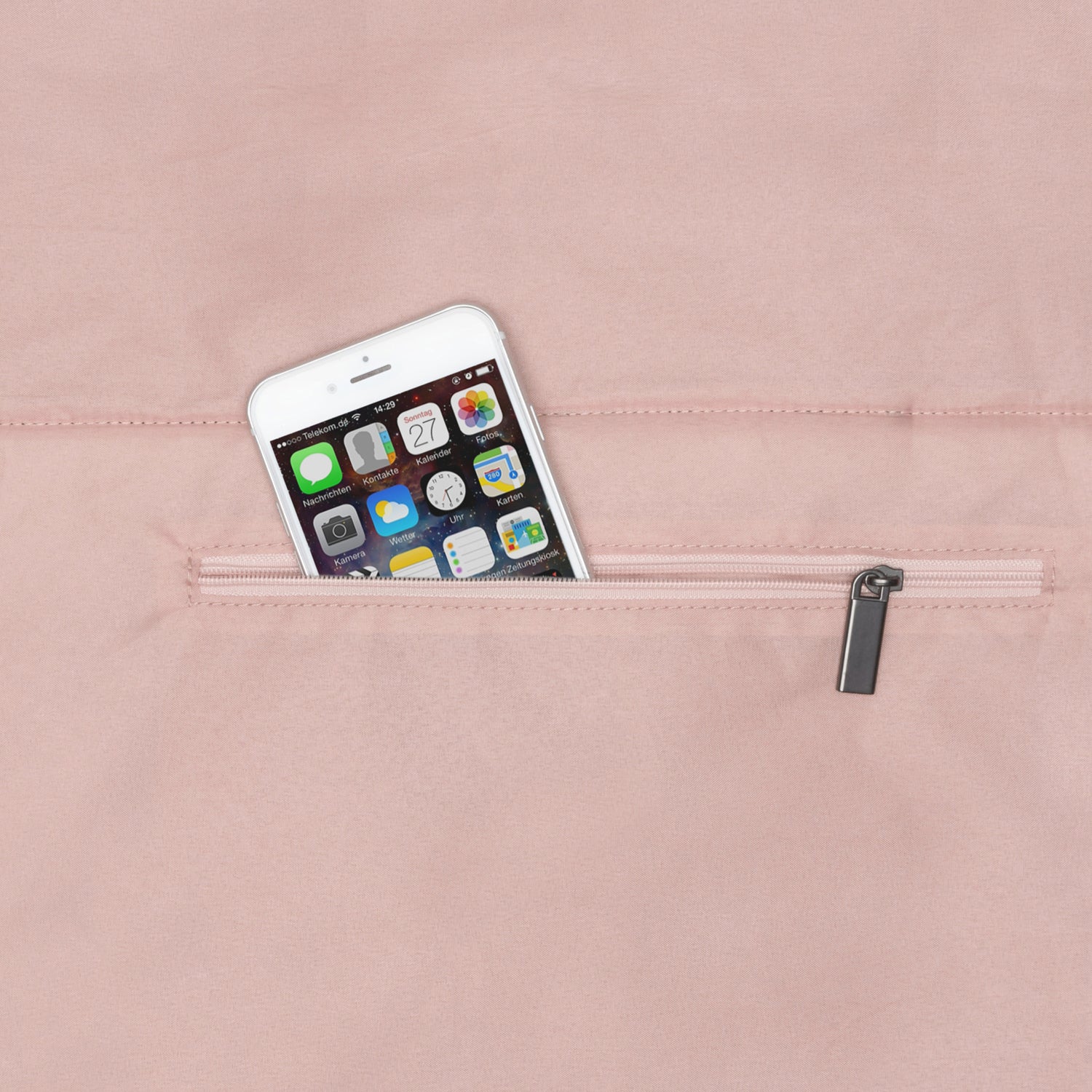 Helles rosa Rucksackfach mit Reißverschluss, darin steckt ein weißes Smartphone