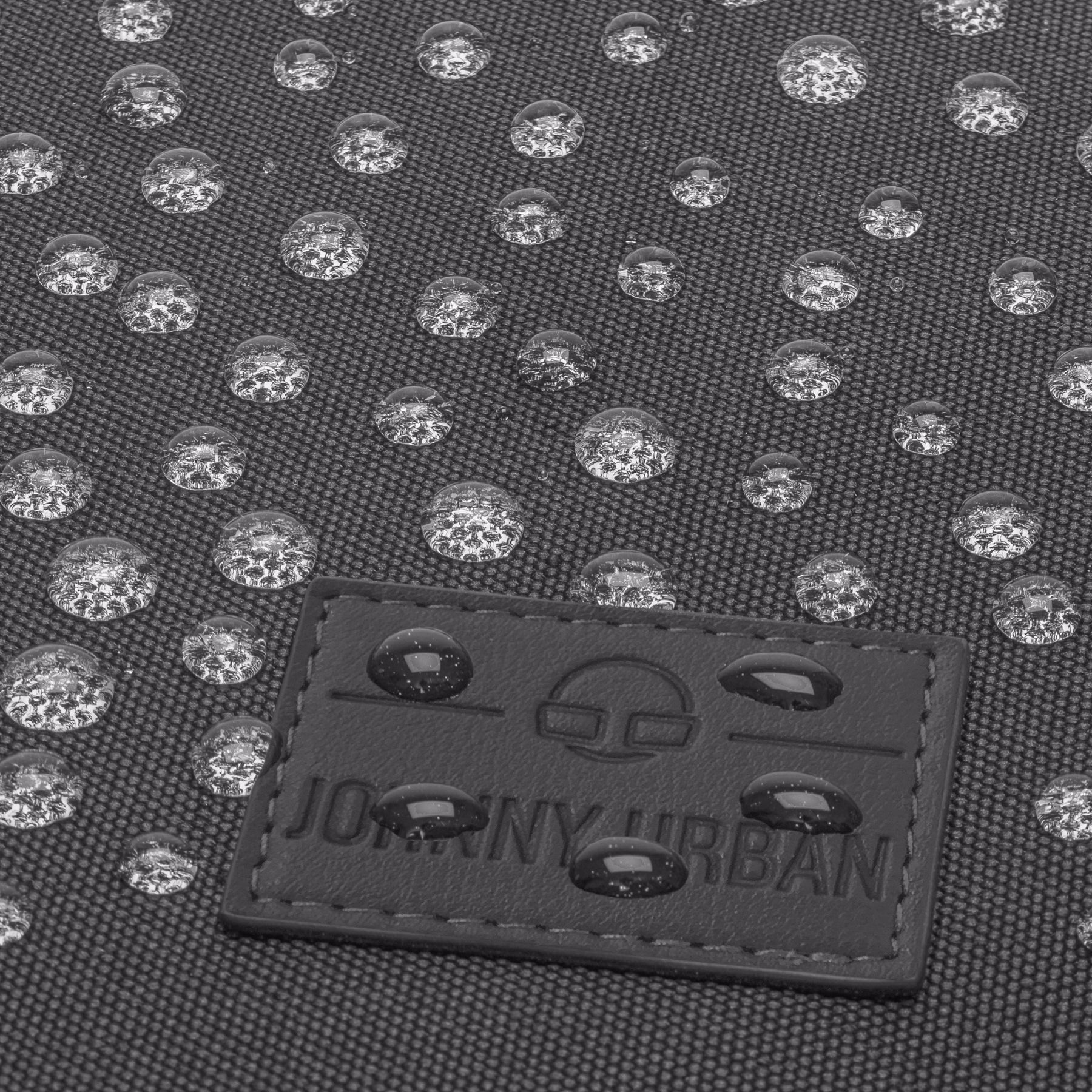 Wasserabweisende Oberfläche der Rucksacktasche 'Ivy' von Johnny Urban mit sichtbaren Wassertropfen