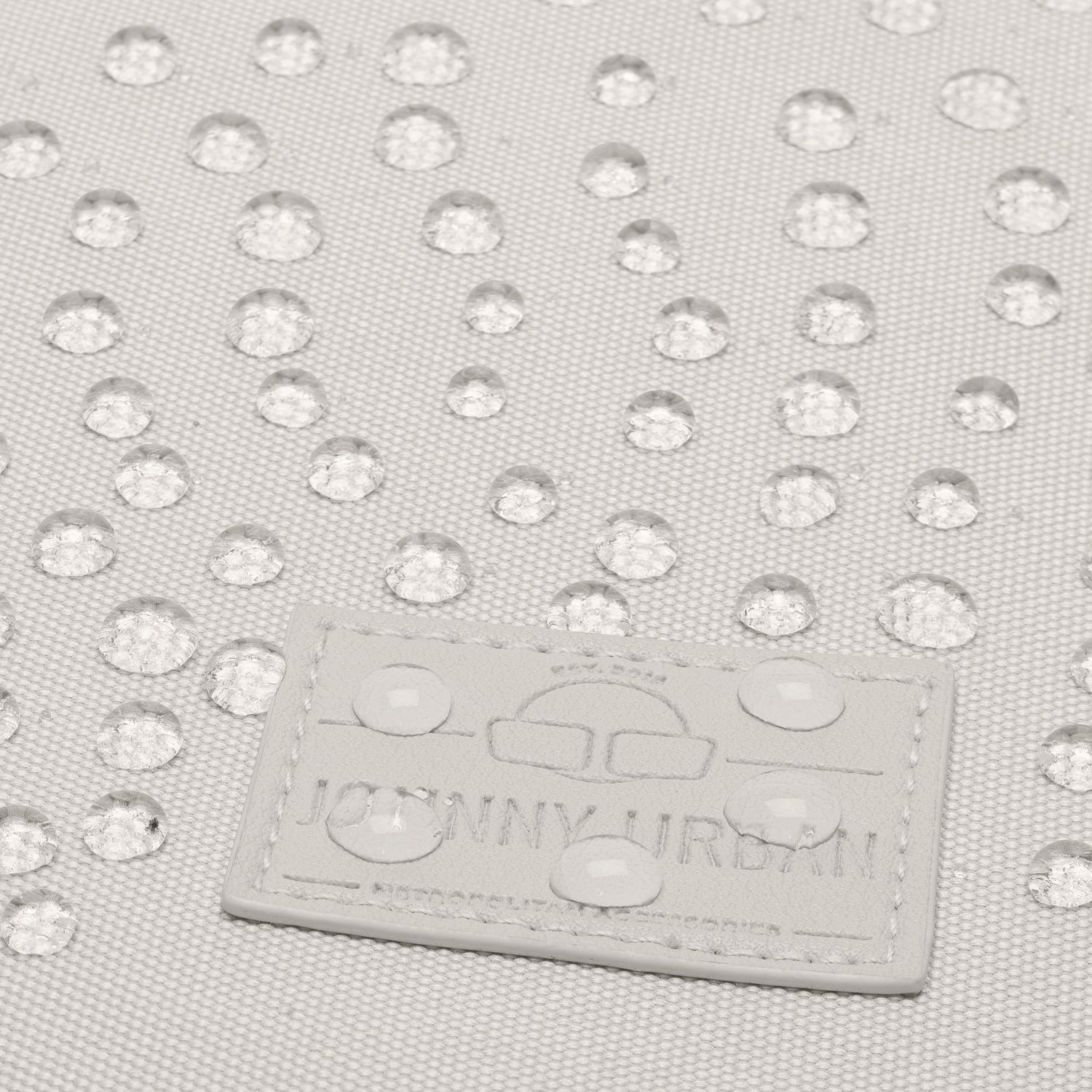 Beige wasserabweisendes Material mit Regentropfen und Johnny Urban Logo auf Tasche